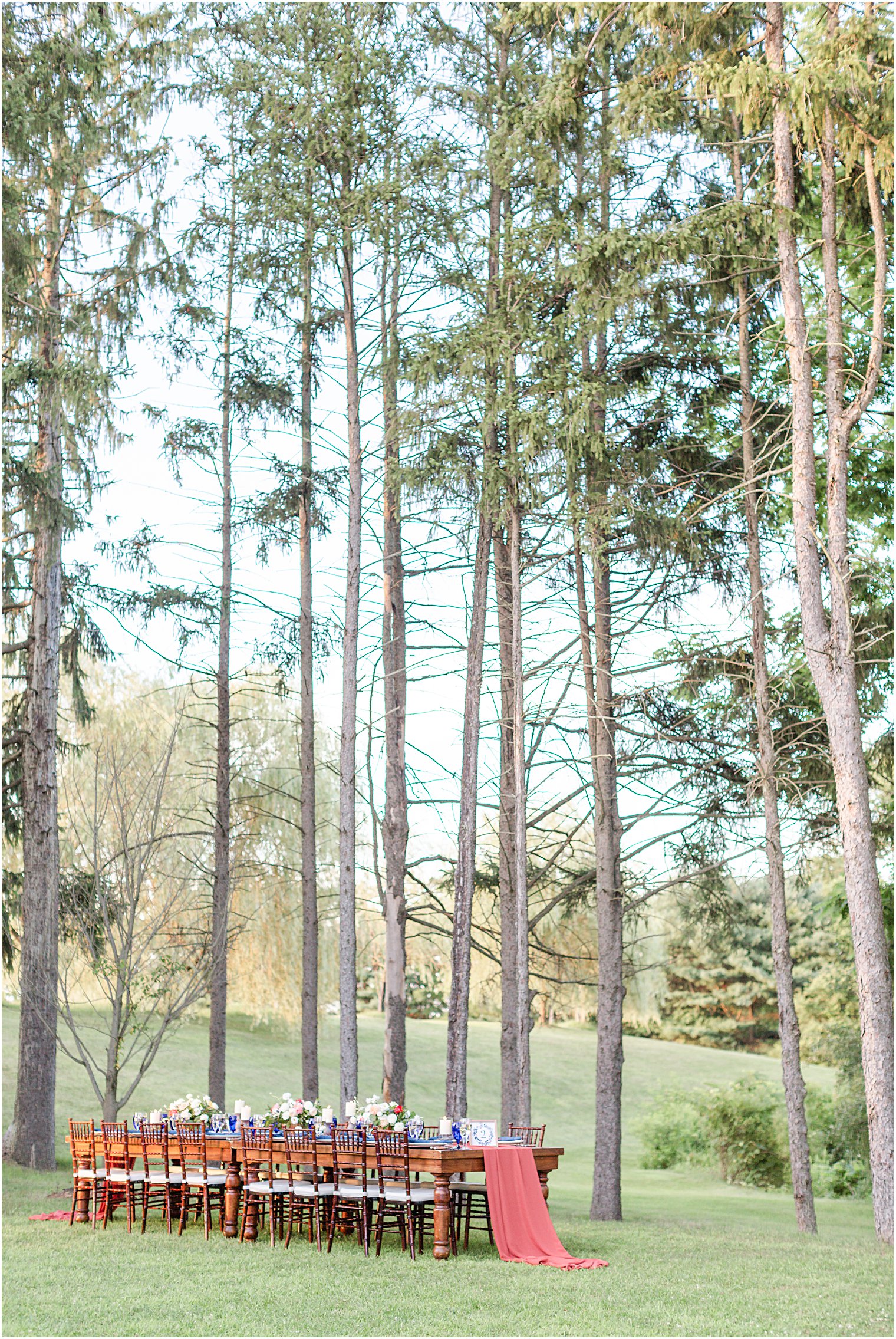 Gorgeous outdoor wedding table setting by tall pine trees