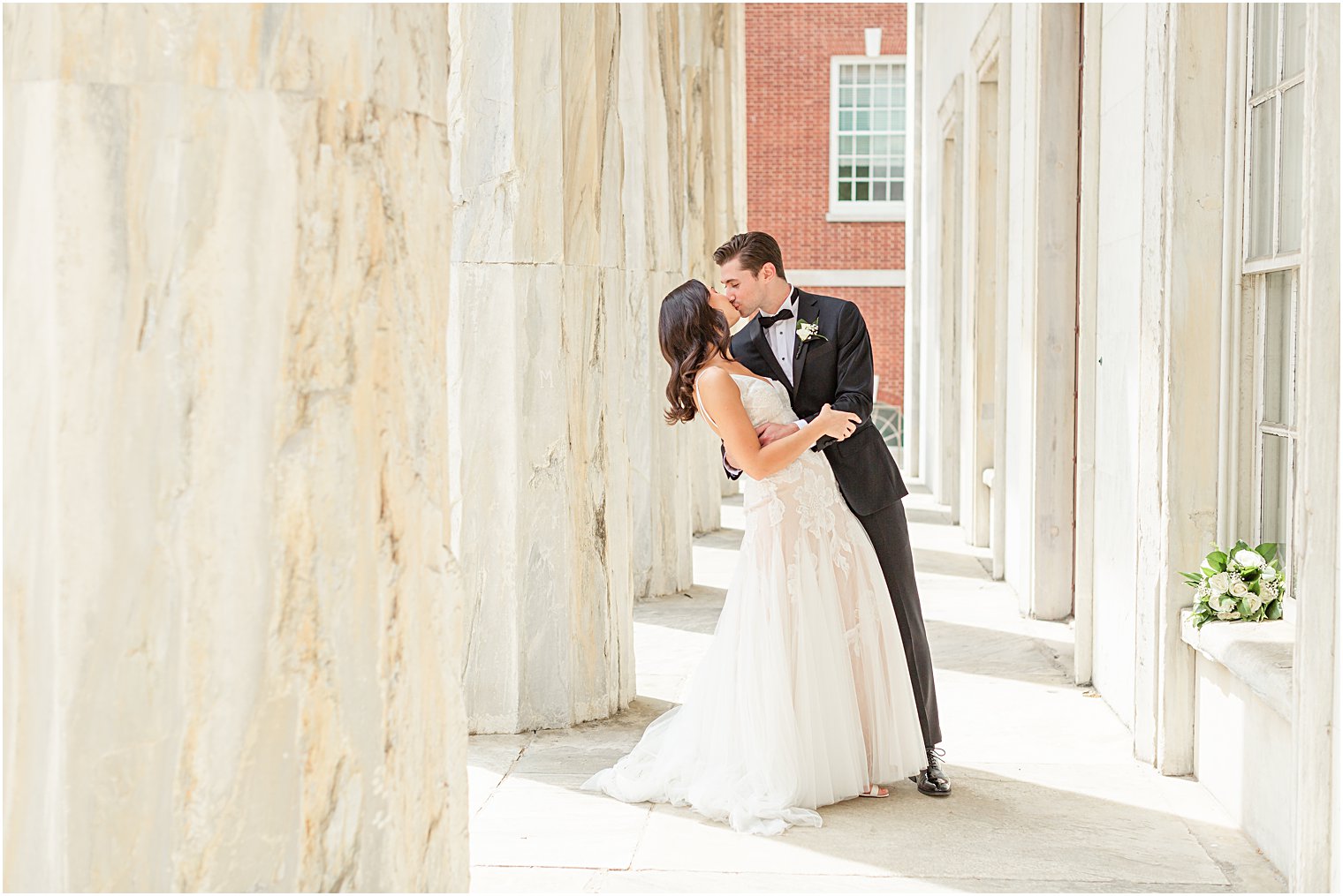 Bride + Groom kiss outside building during first look at Philadelphia PA Wedding at Franklin Square  