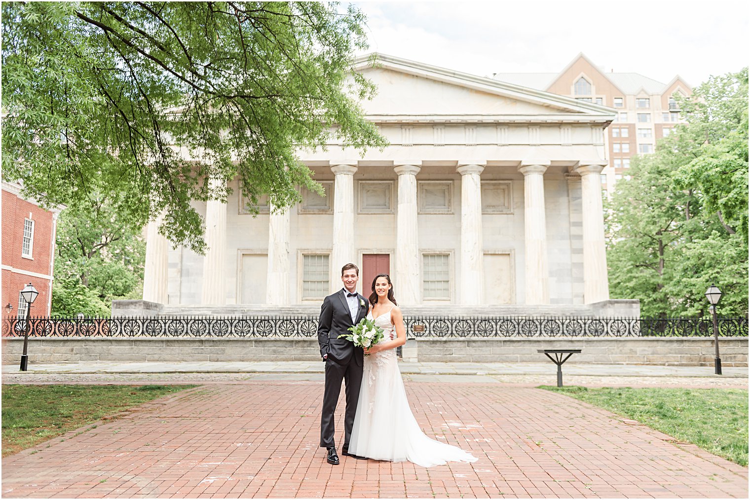 Bride + Groom stand outside in front of white building before Philadelphia Wedding at Franklin Square