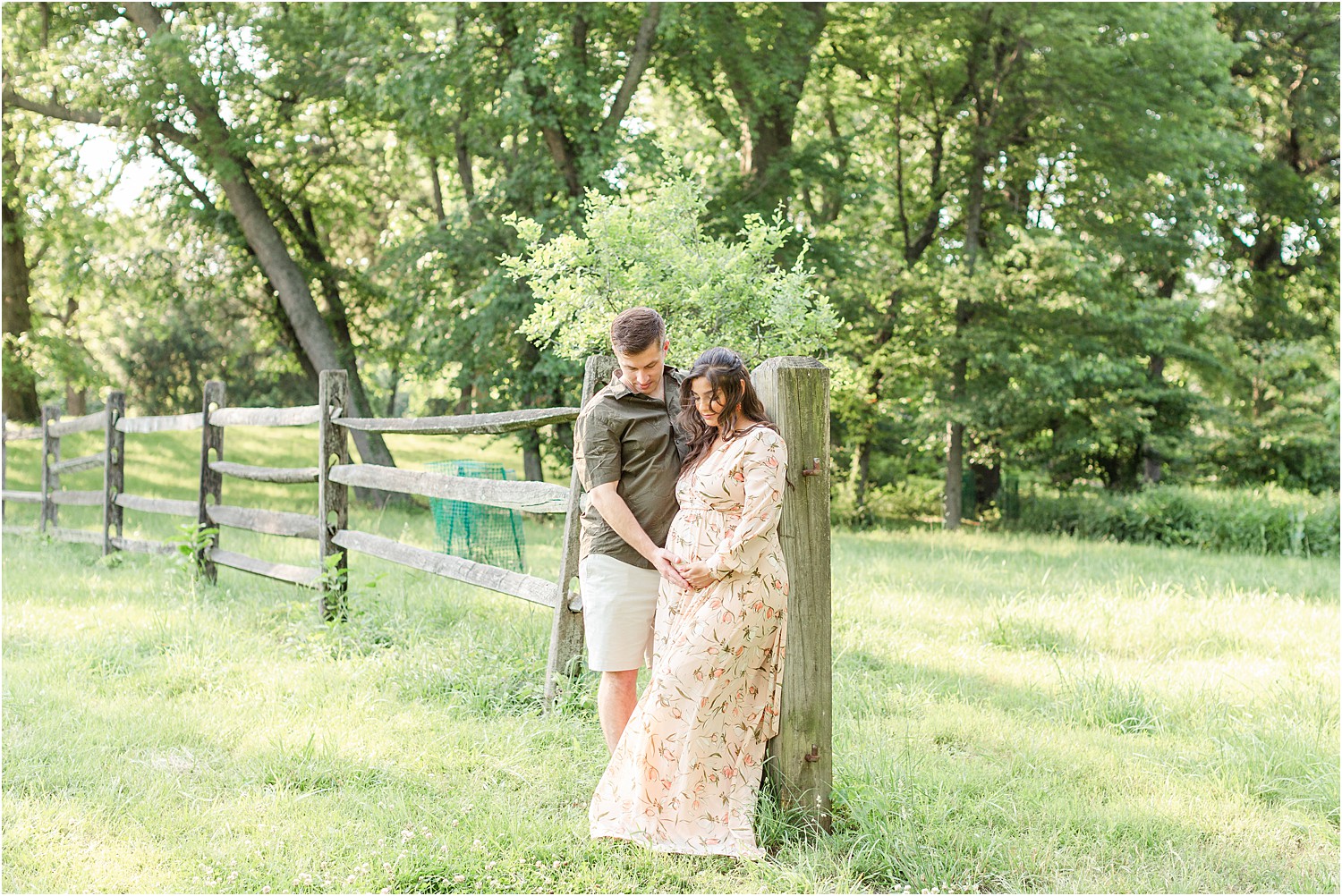 husband touches pregnant wife's baby bump during photo session