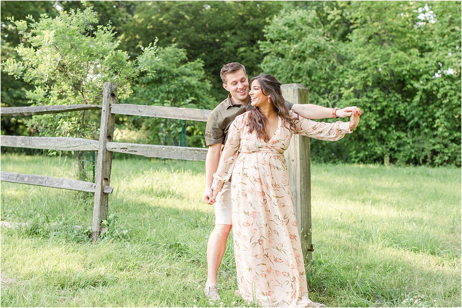 candid photo of couple dancing by fence post