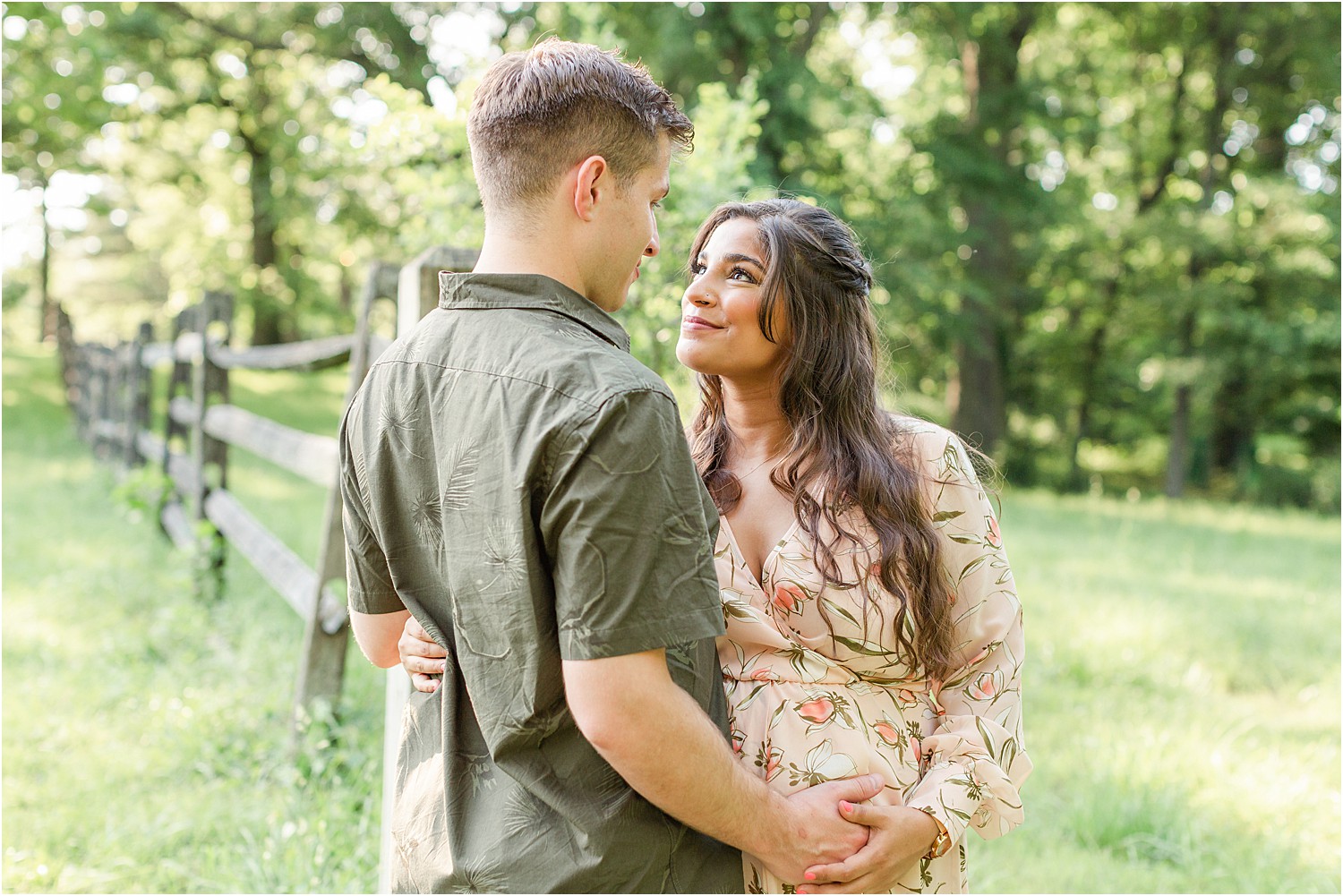 wife looks up at husband during outdoor maternity session