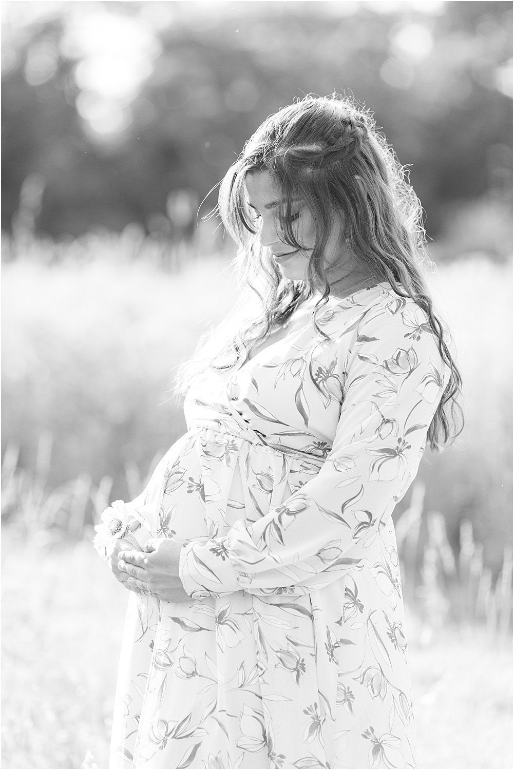 pregnant woman looks down at belly during Bartram’s Garden Maternity session