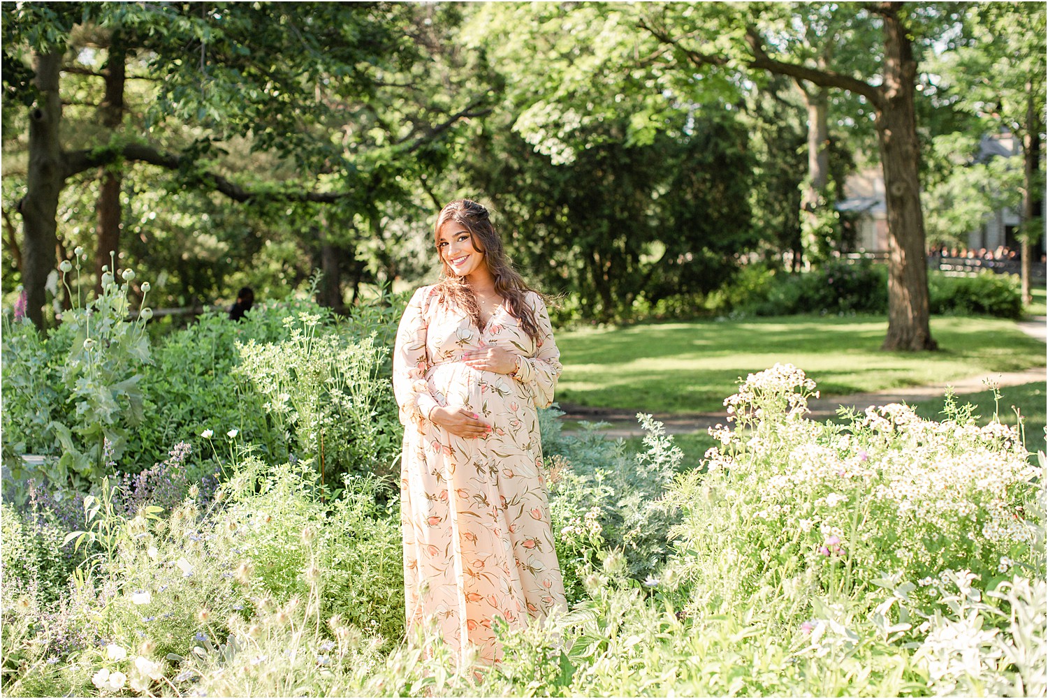 Mom holds baby bump in field of green grass in PA