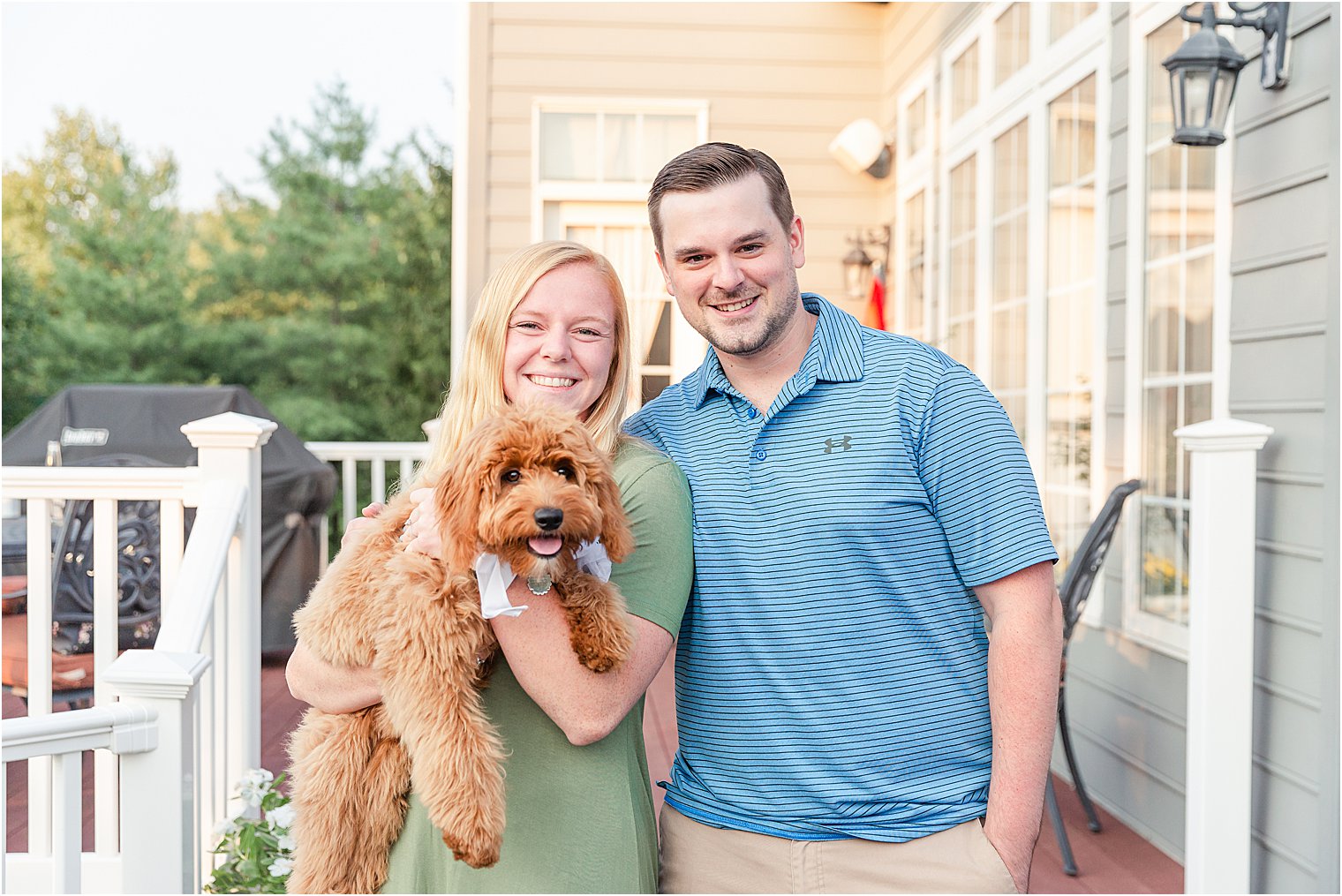 Newly engaged couple hold their dog after proposal 