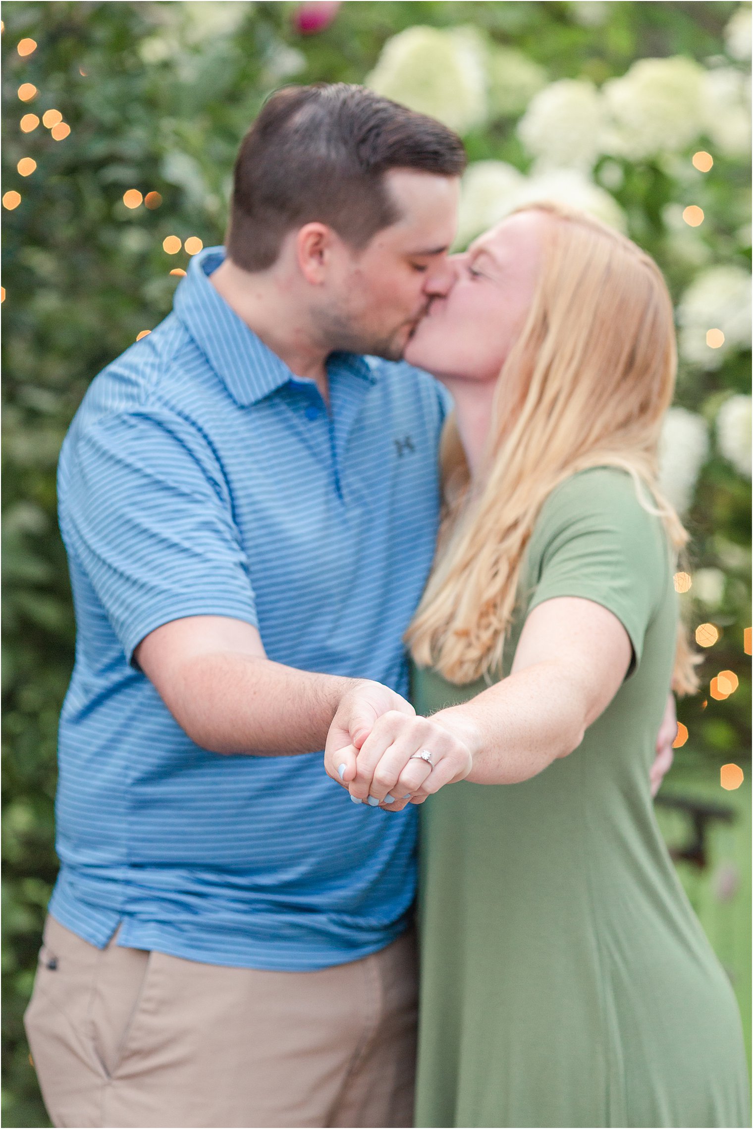 Couple kisses + shows of engagement ring after backyard proposal 