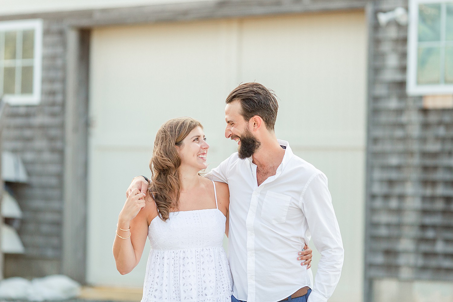 couple laughs together while having their engagement photos taken