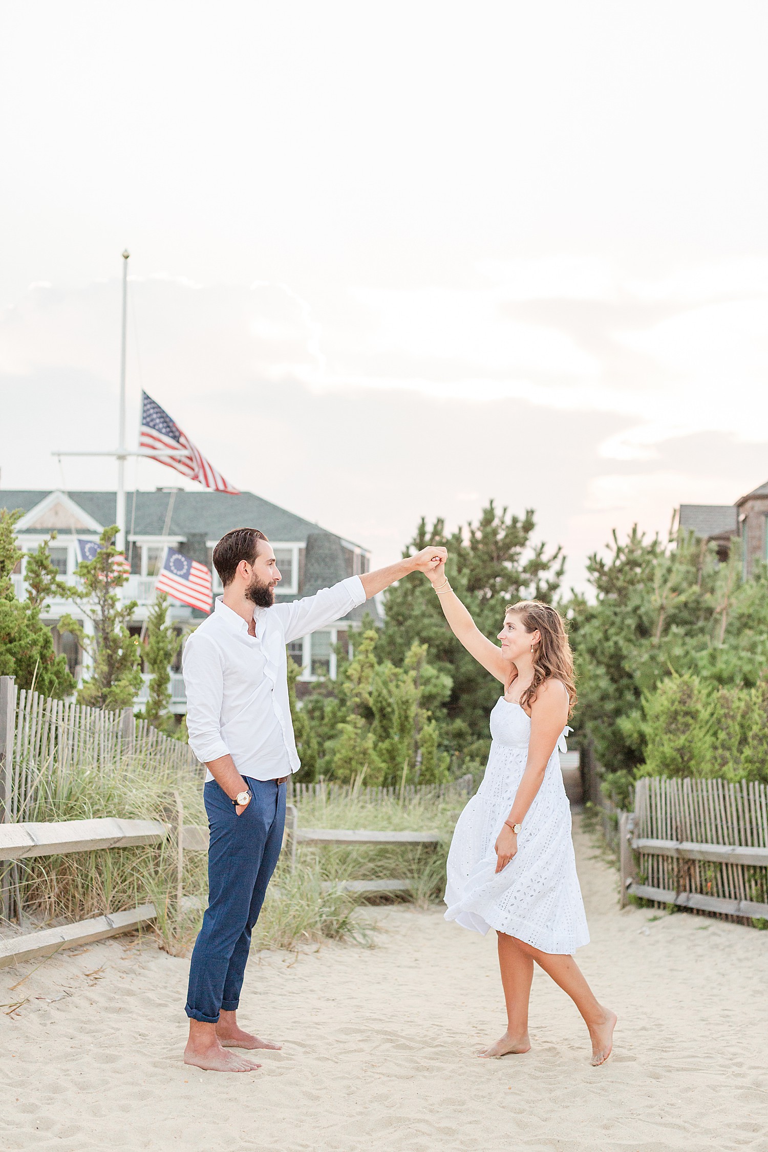 engaged couple dance and man twirls fiance during Bayhead Yacht Club + Beach engagement session