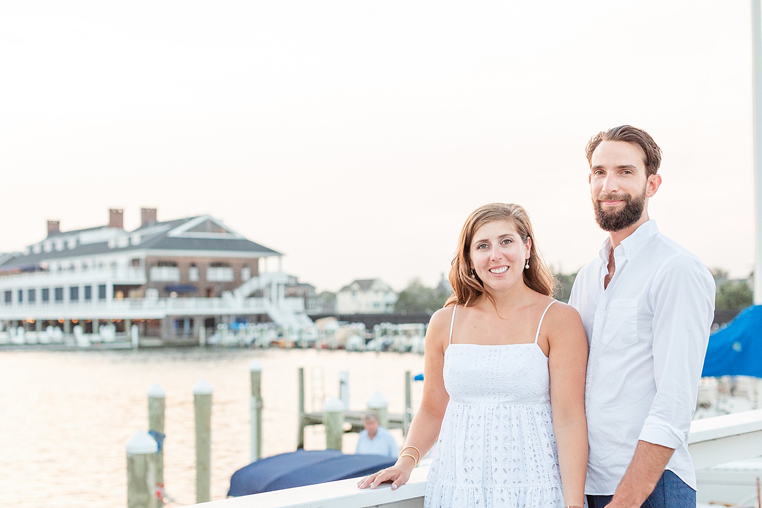 Couple looks out over water at the Bay Head Yacht Club during engagement session