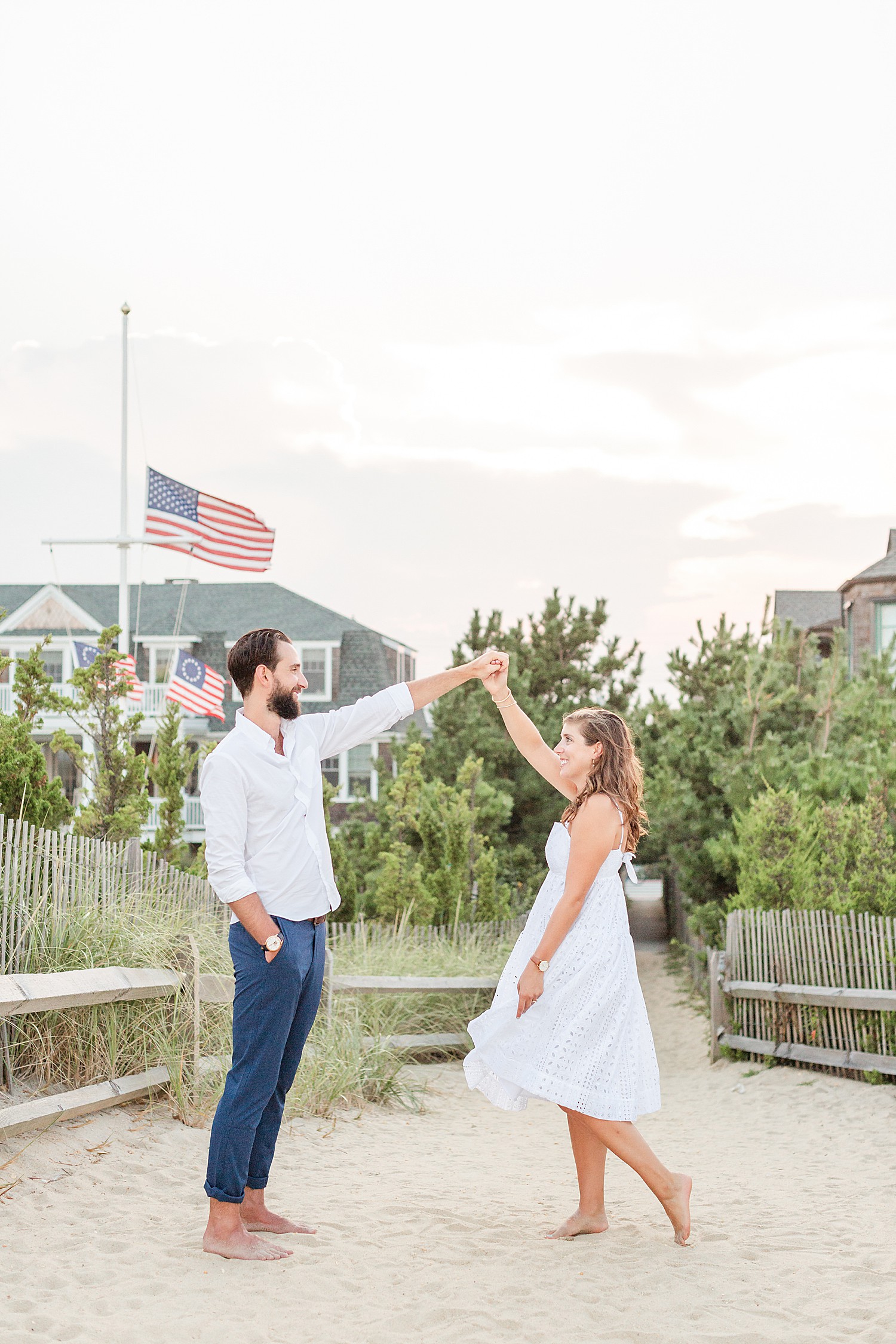 engaged couple dance and man twirls fiance during Bay Head Beach engagement session