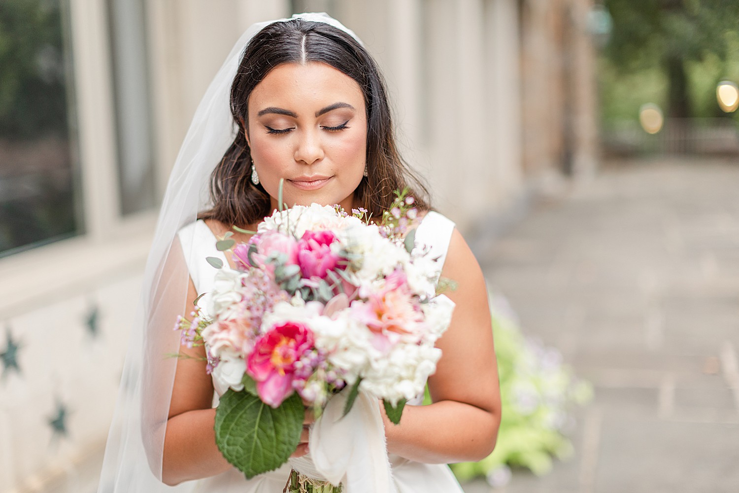 bride holds up wedding bouquet to her face