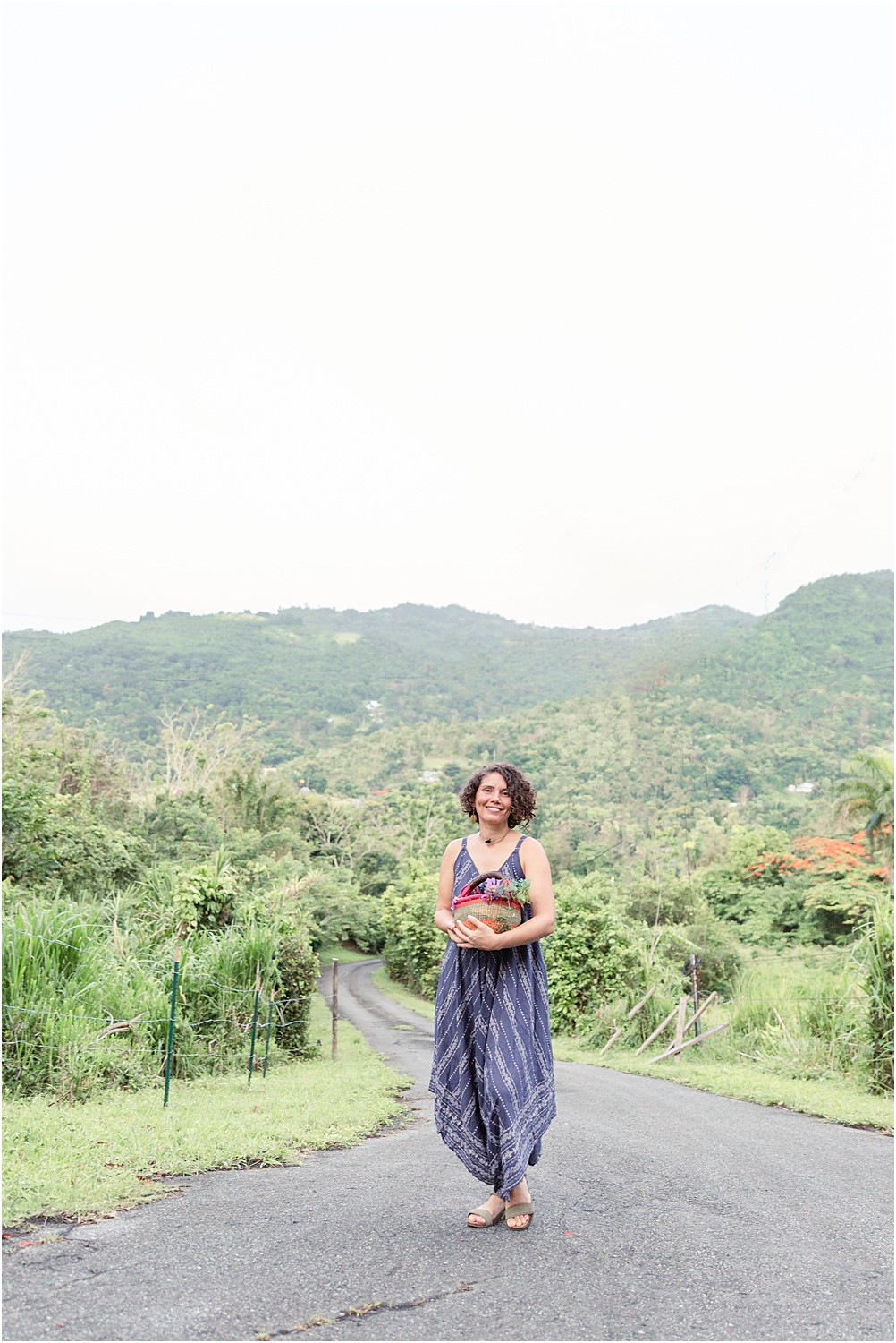 woman stands on in the countryside of Puerto Rico with Mountains in background