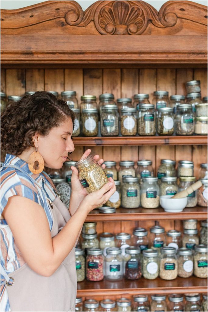 business owner smells herbs she uses for healing and wellness