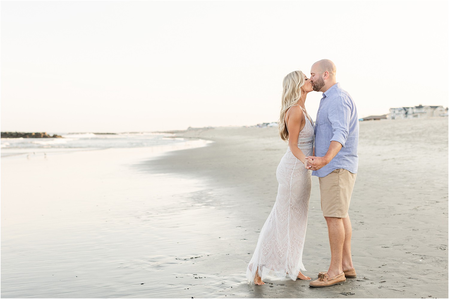 engaged couple kiss at the ocean shoreline in NJ Belmar Beach