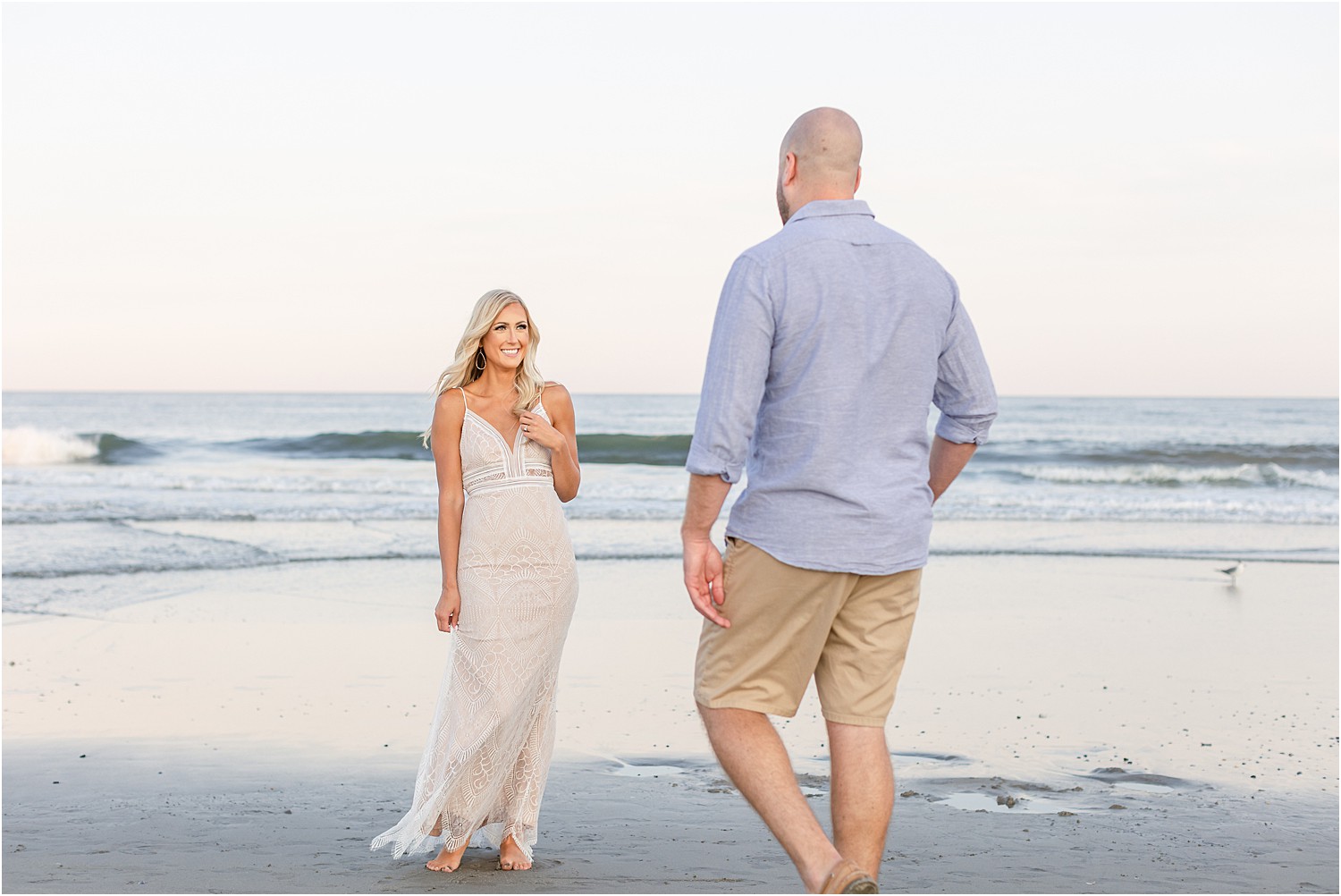 woman stands in front of fiance at belmar beach 