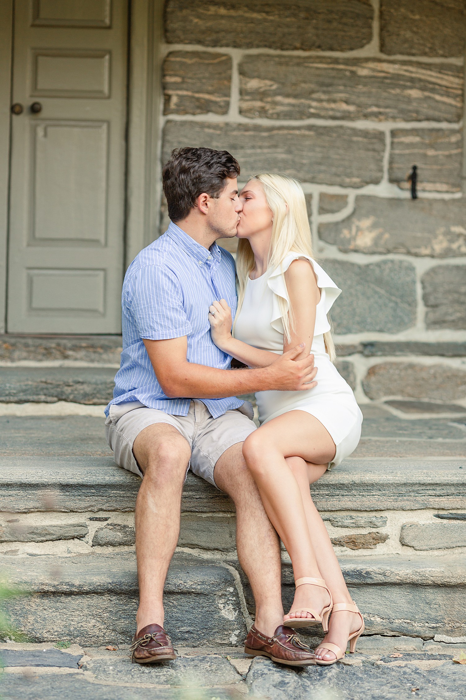 couple kiss on stone porch at Bartram’s Garden