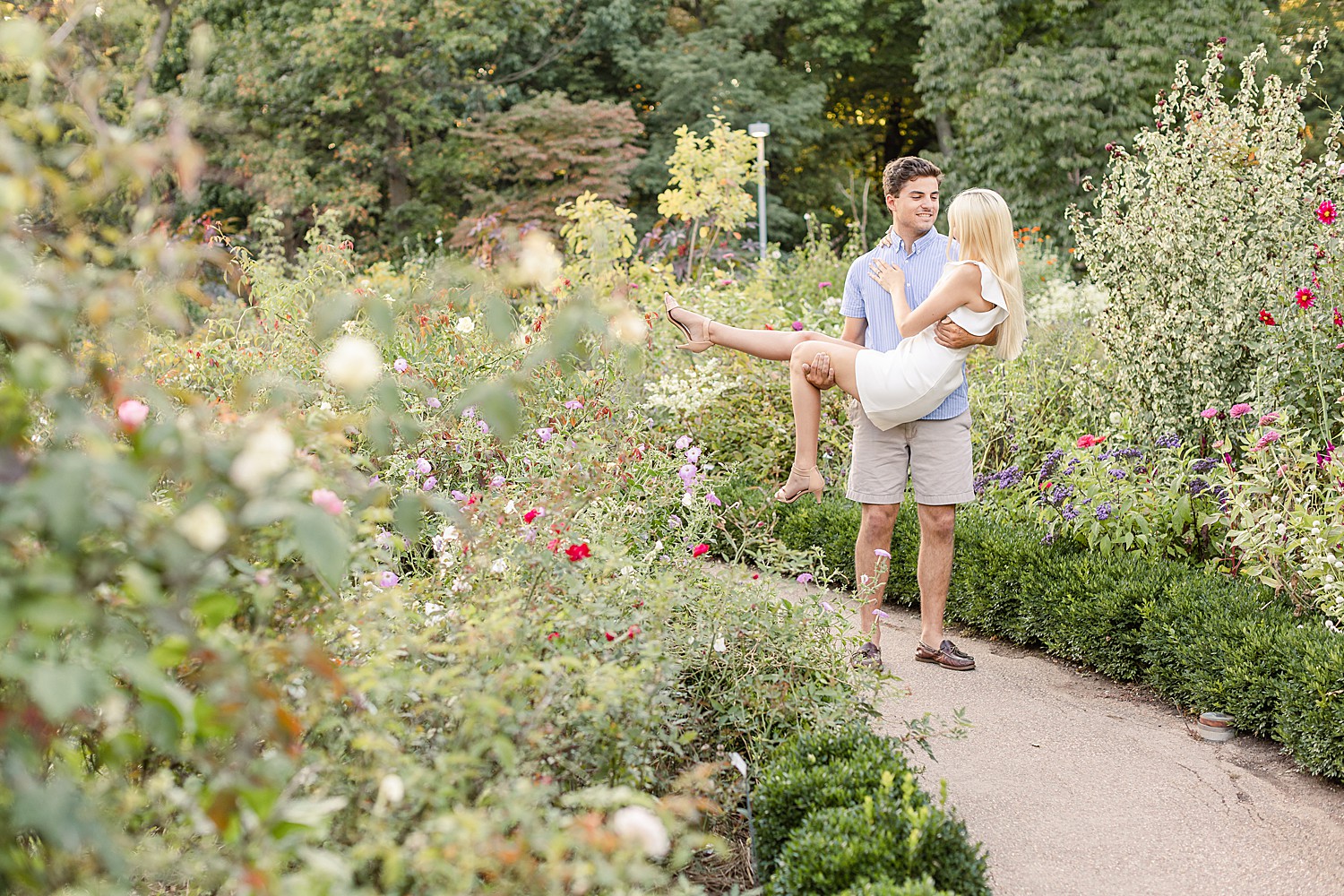 guy lifts up fiance in beautiful garden setting in PA