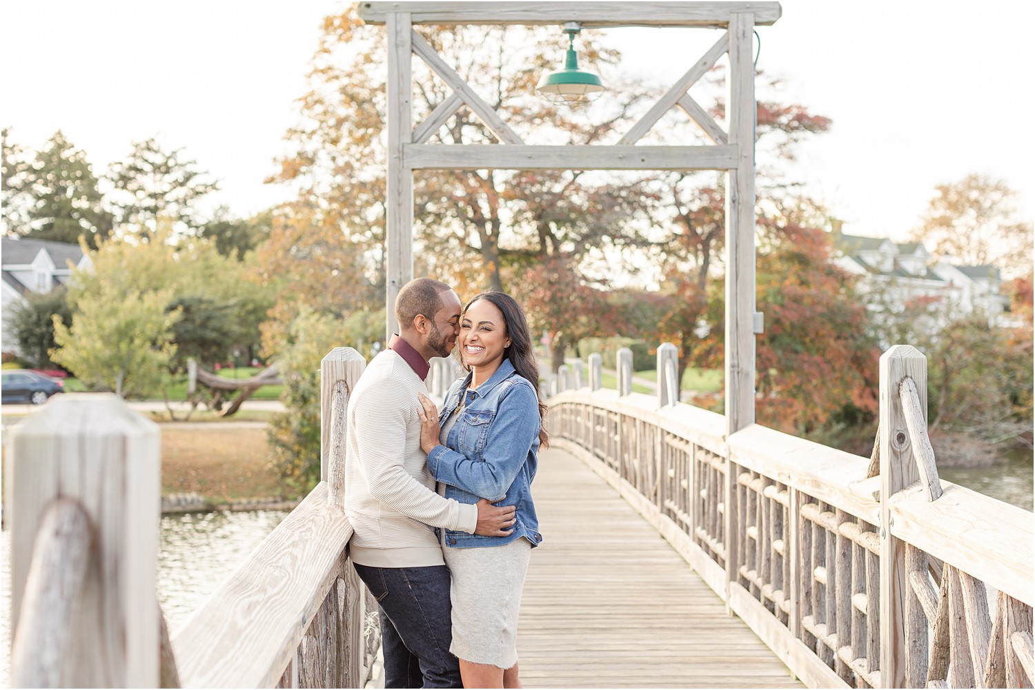 Engaged couple on bridge over water in NJ