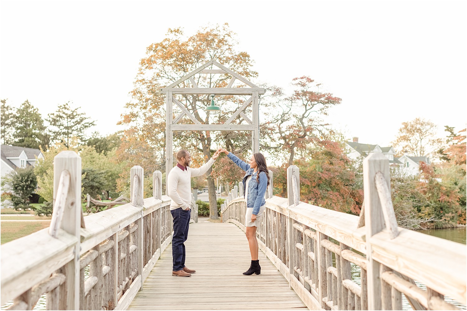 man twirls his fiance on bridge in Spring Lake Park NJ