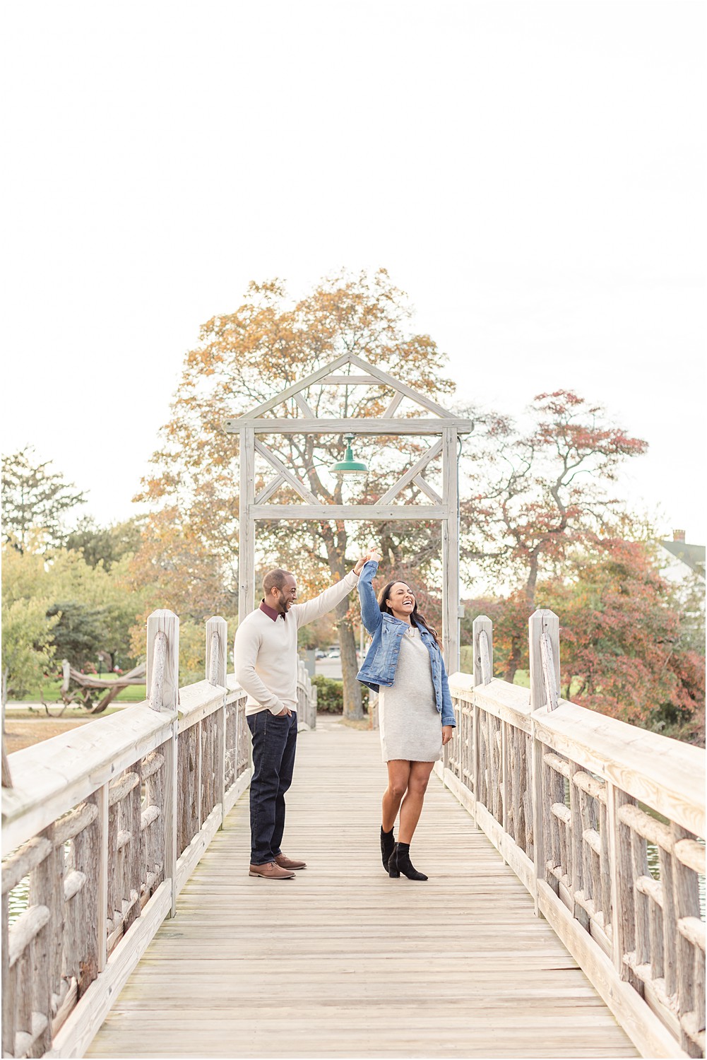 couple dance on bridge during Spring Lake fall engagement photos