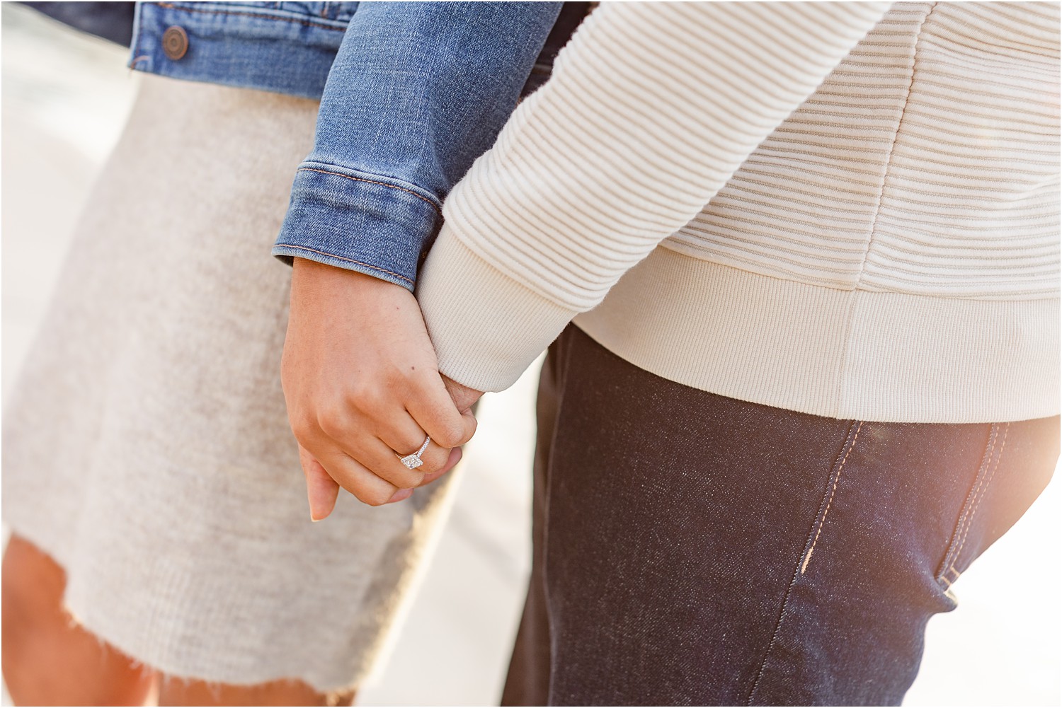 couple holding hands showing off engagement ring