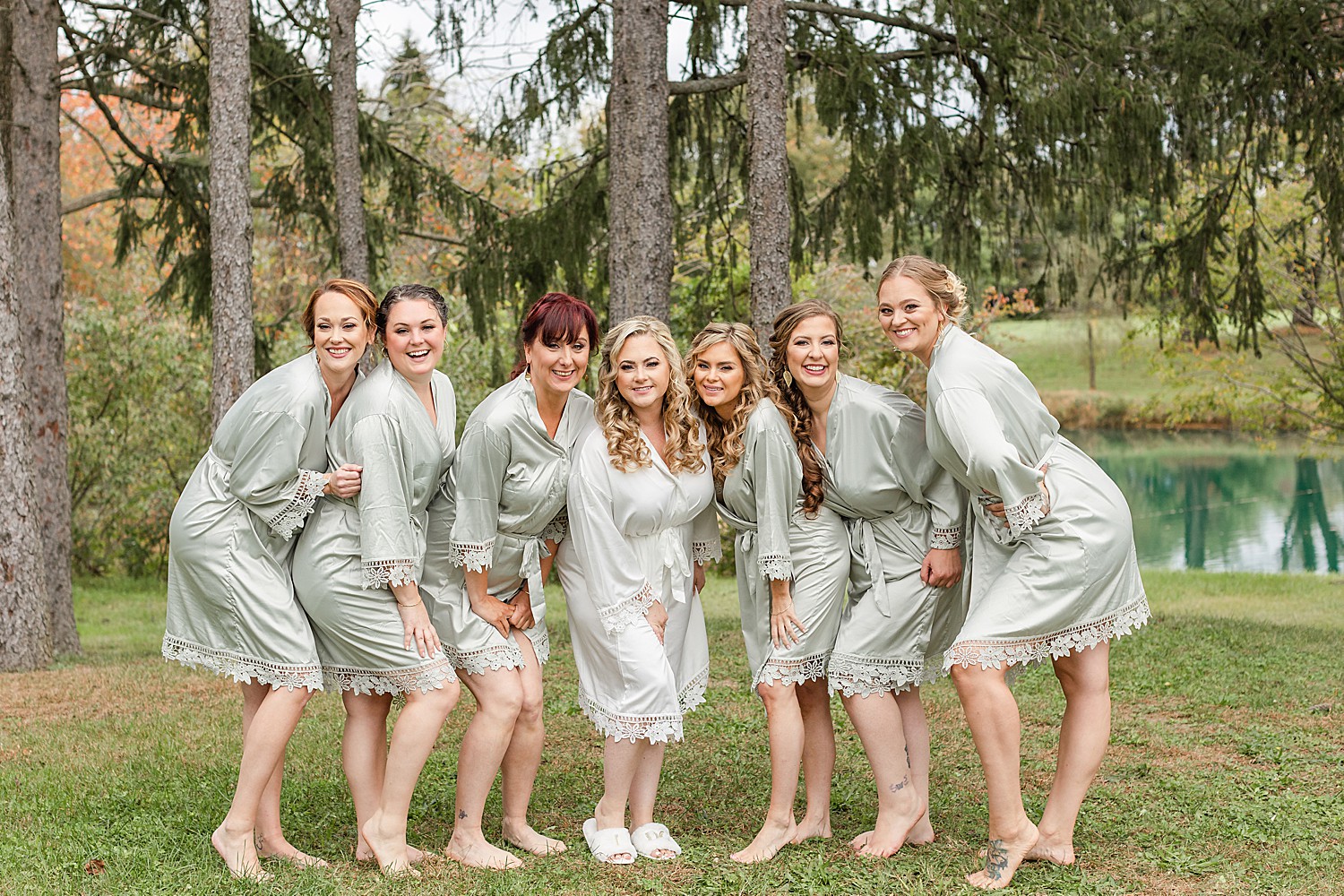bridesmaids outside in matching sage green silk robes 