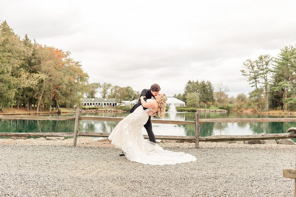 couple kiss near pond at Windows on the Water at Frogbridge NJ wedding