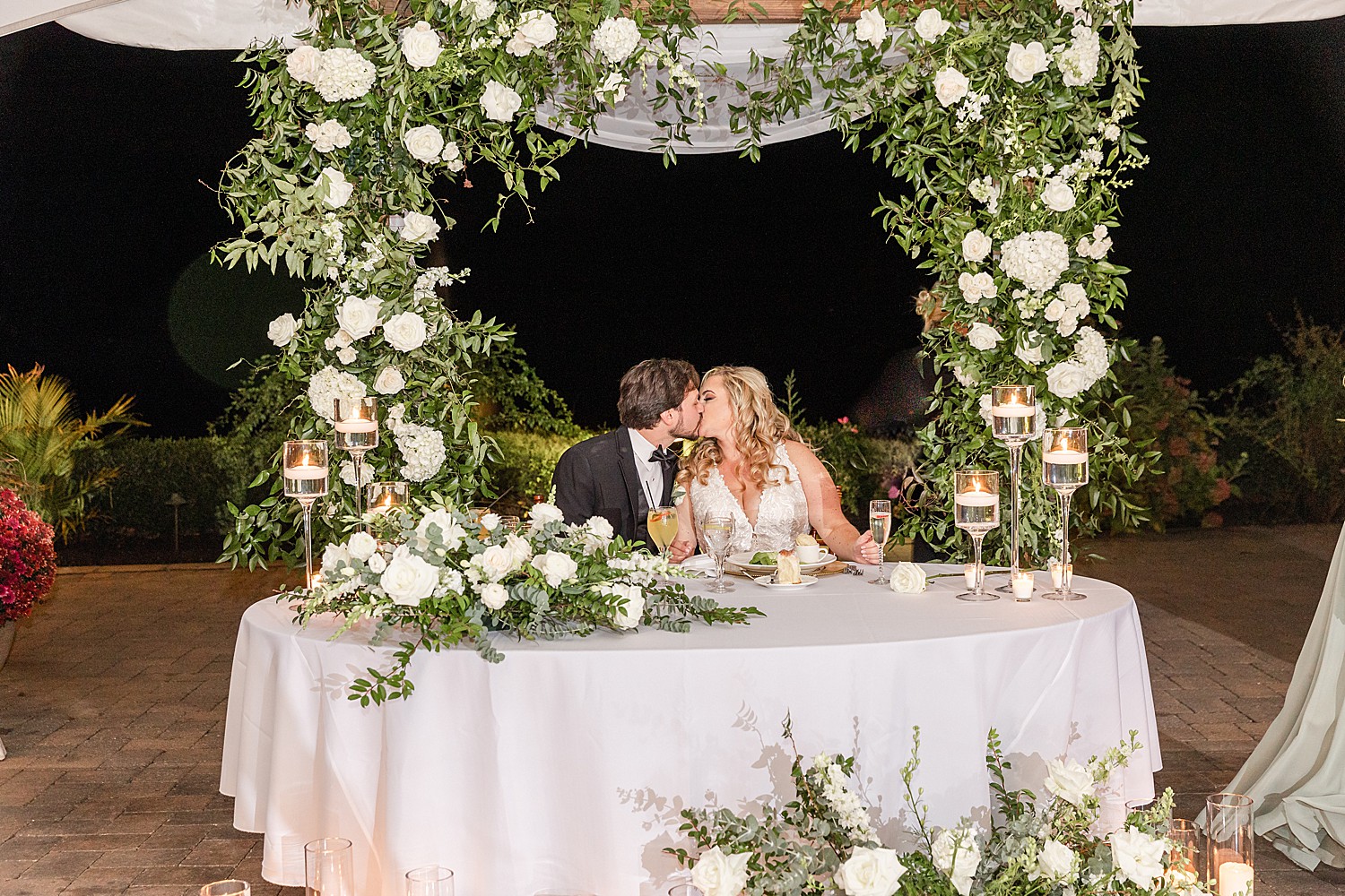 bride and groom kiss at head table