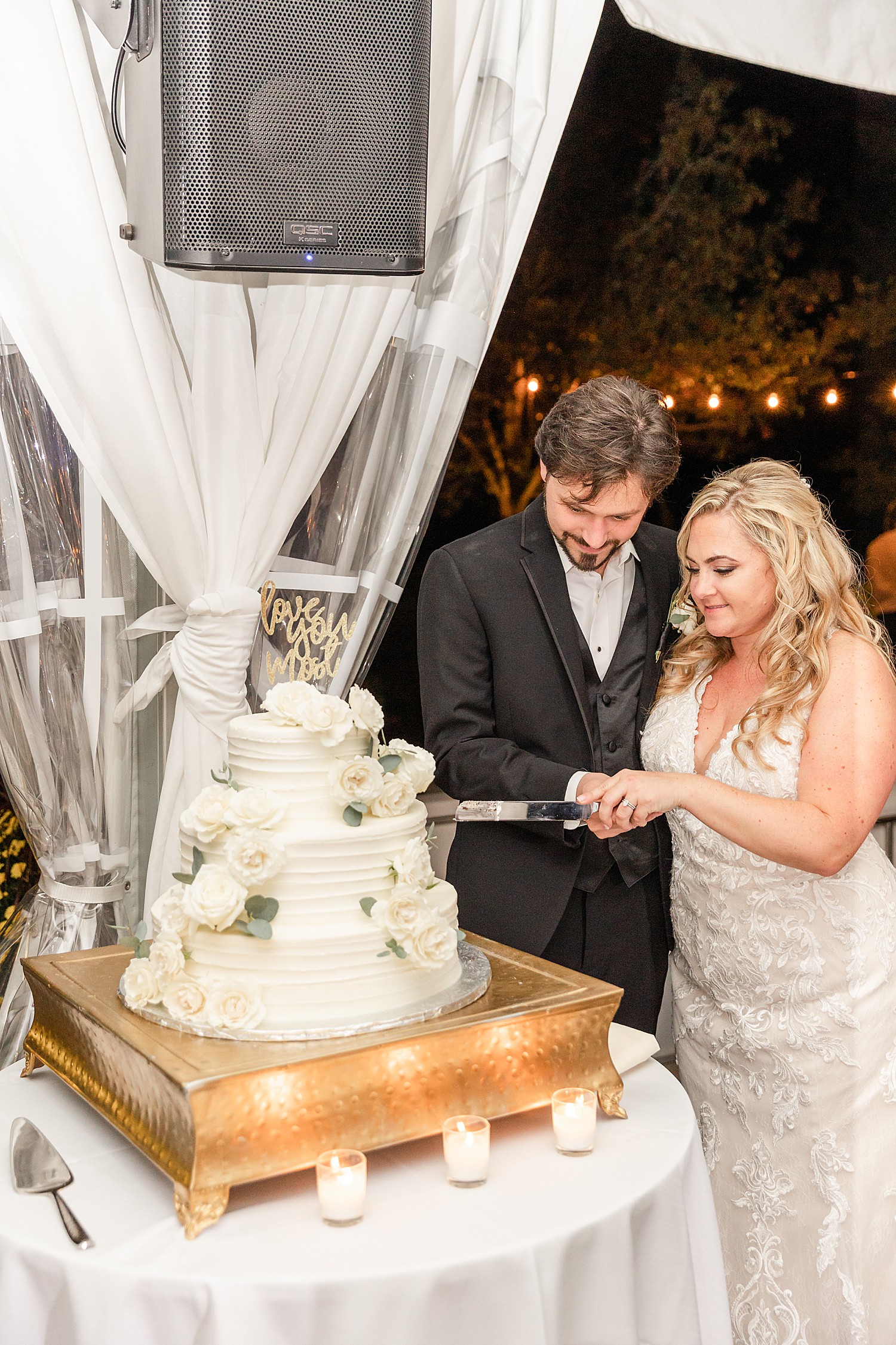 couple cutting their 3 tiered wedding cake