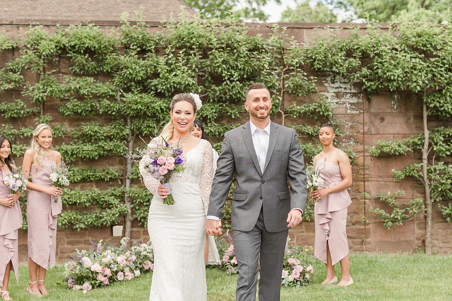 newlyweds hold hands and walk back down the aisle together