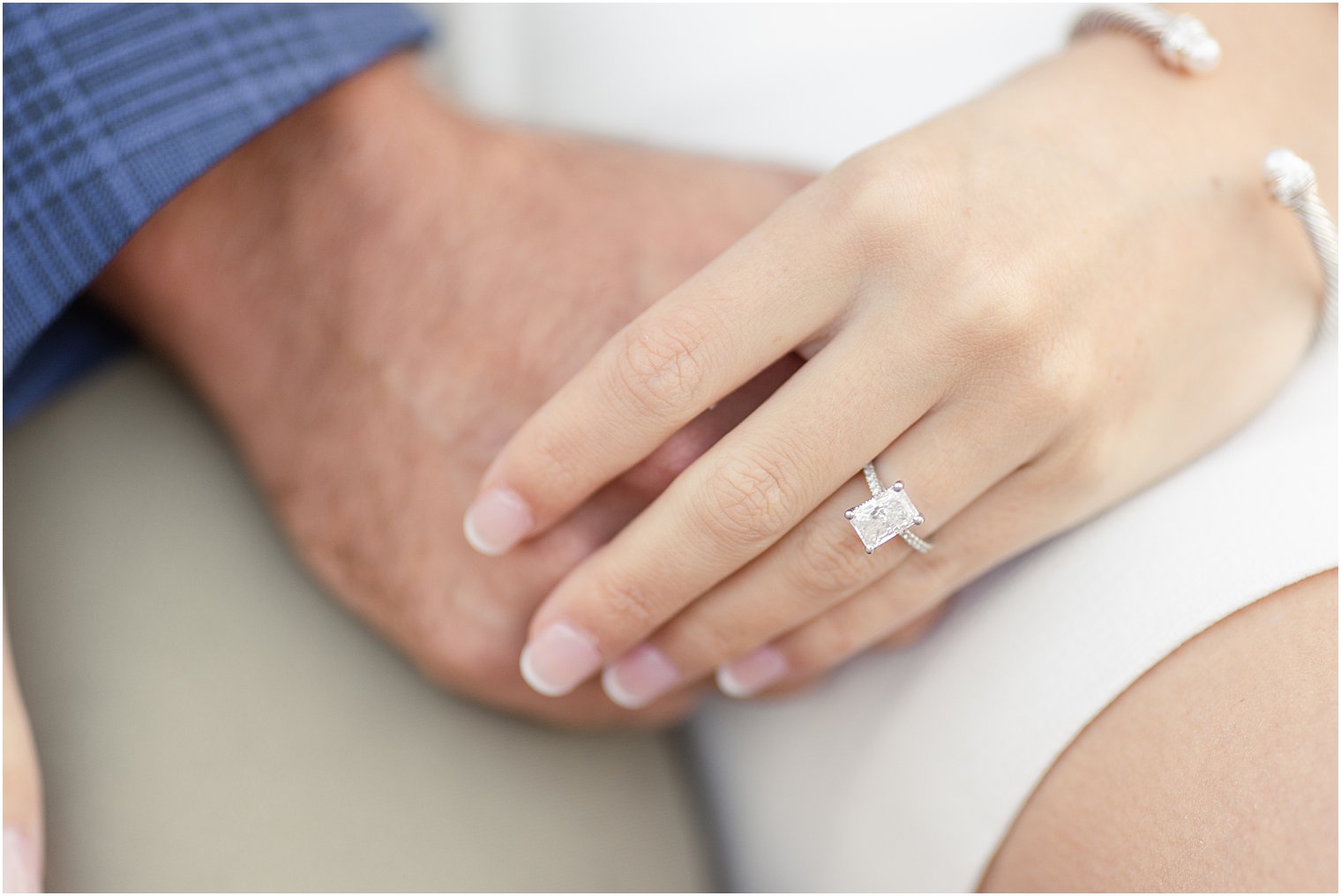 couple holding hands showing beautiful engagement ring