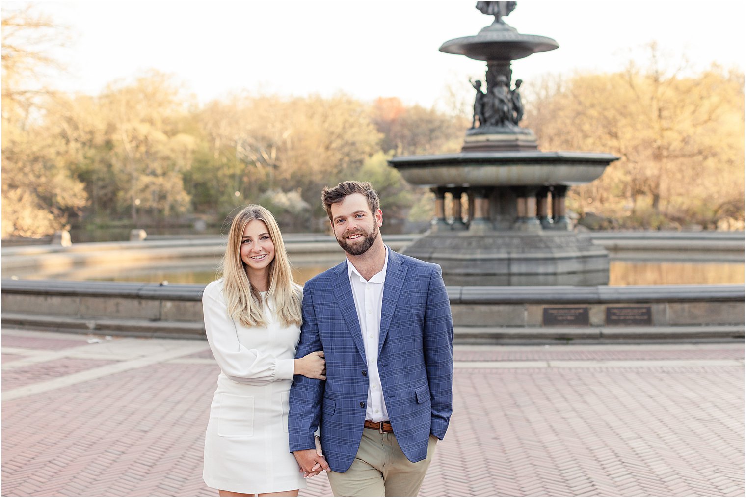 couple walking through central park together during engagement portraits 