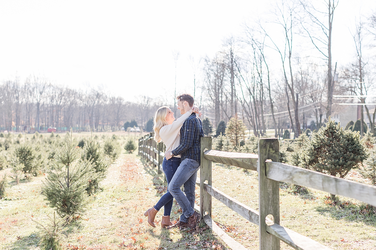 couple lean against wooden fence