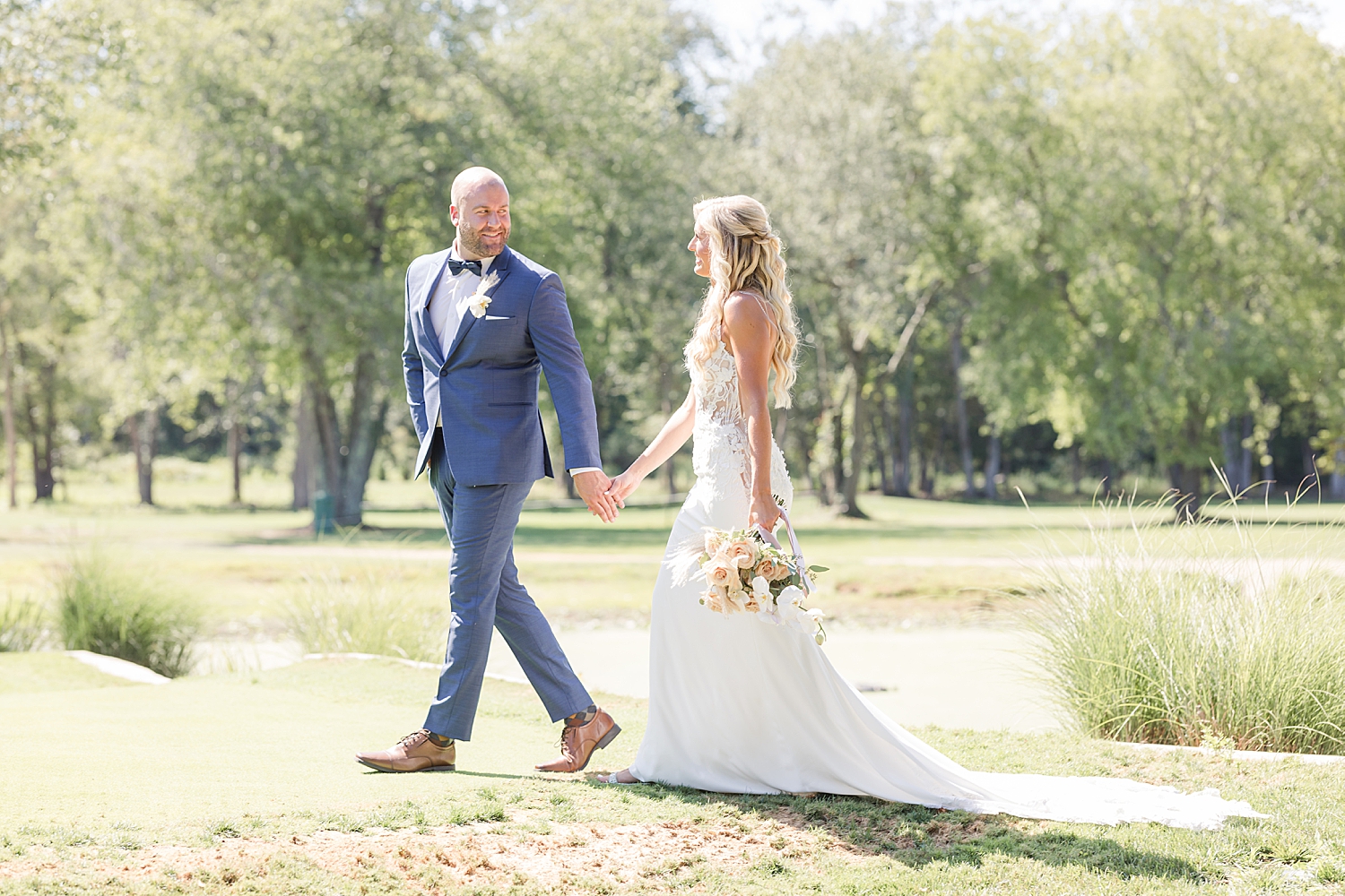 couple walk across golf course holding hands