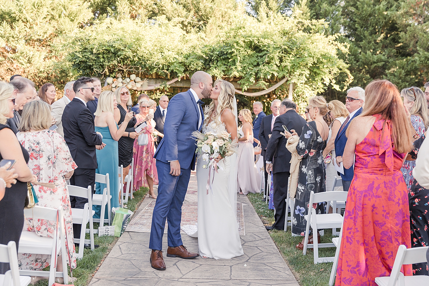 newlyweds kiss as they exit wedding ceremony