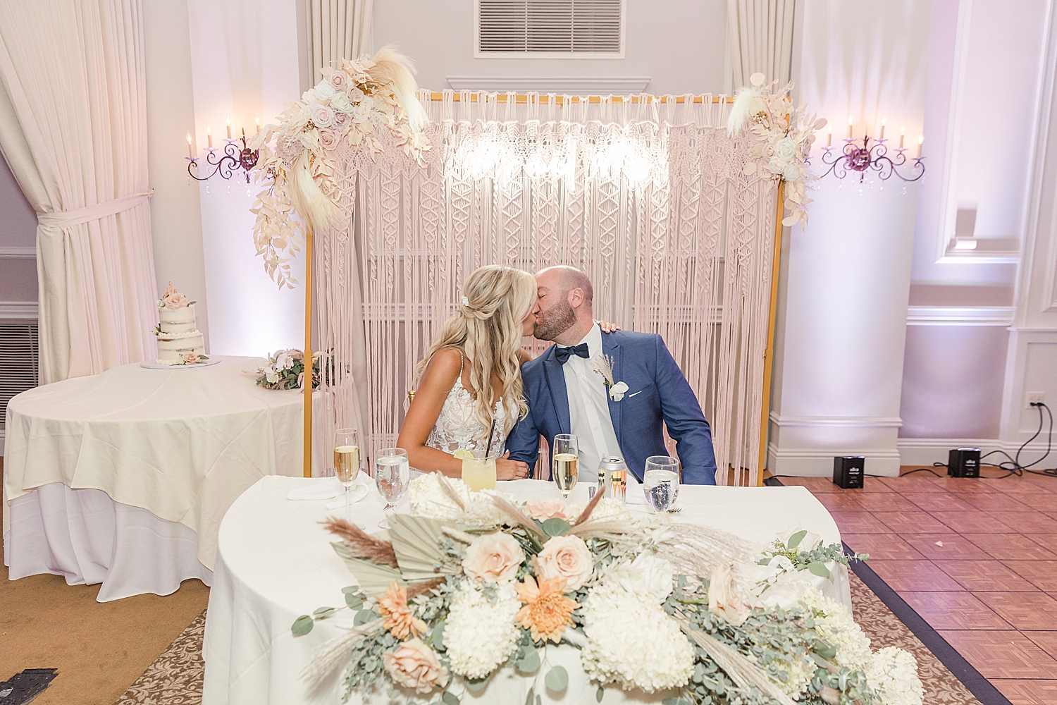 bride and groom kiss during Boho Inspired Summer Wedding reception at Eastlyn Golf Course