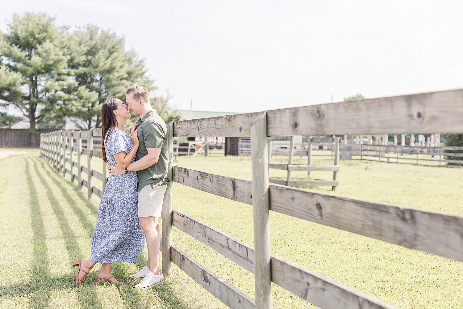 couple lean against fence post at New Jersey Engagement at William Heritage Winery in Mullica Hill