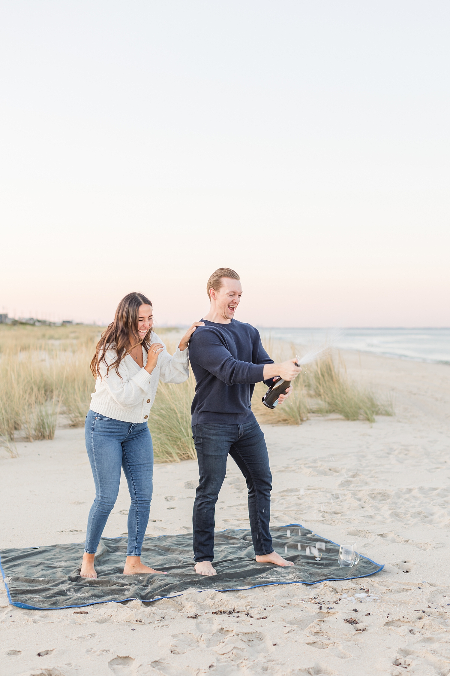 couple laughs as champagne sprays everywhere