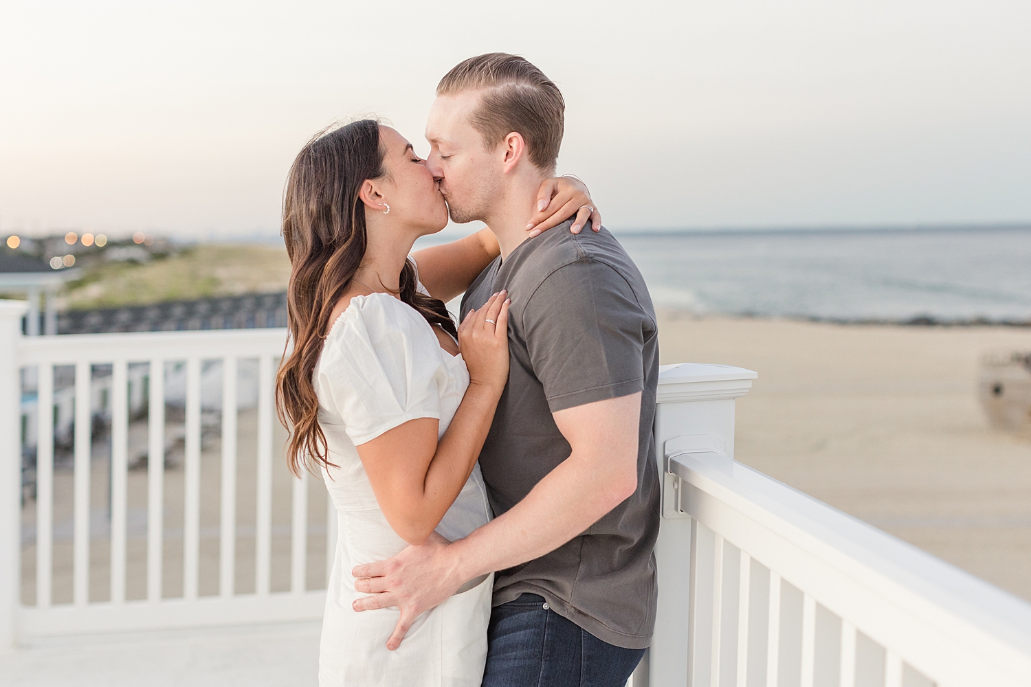 engaged couple kiss on ballcony