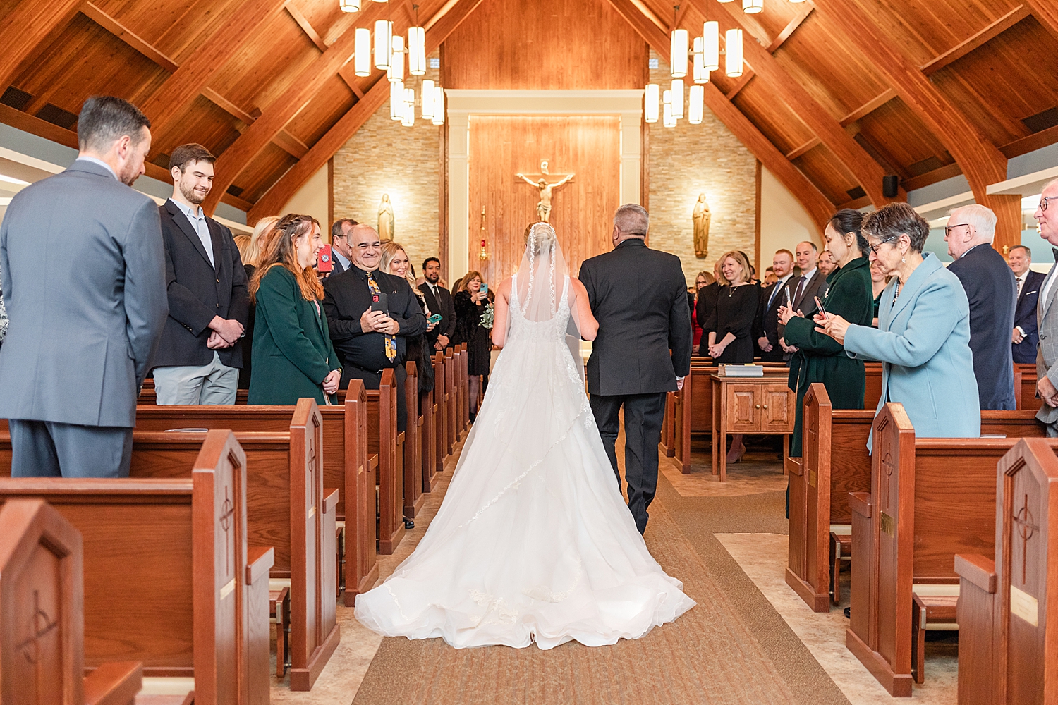 back of bride's wedding dress as she walks down the aisle 