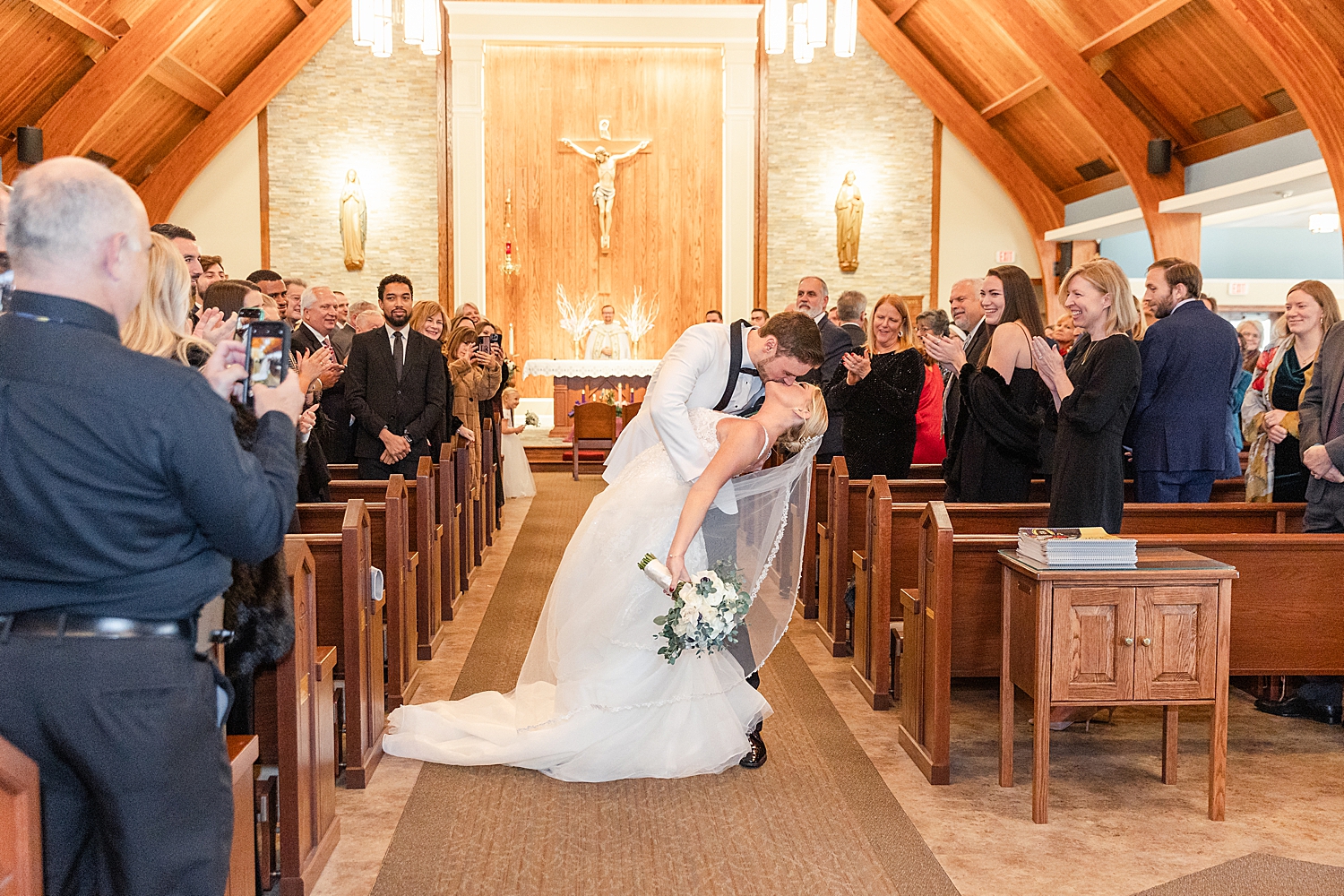 groom dips his bride and they kiss 