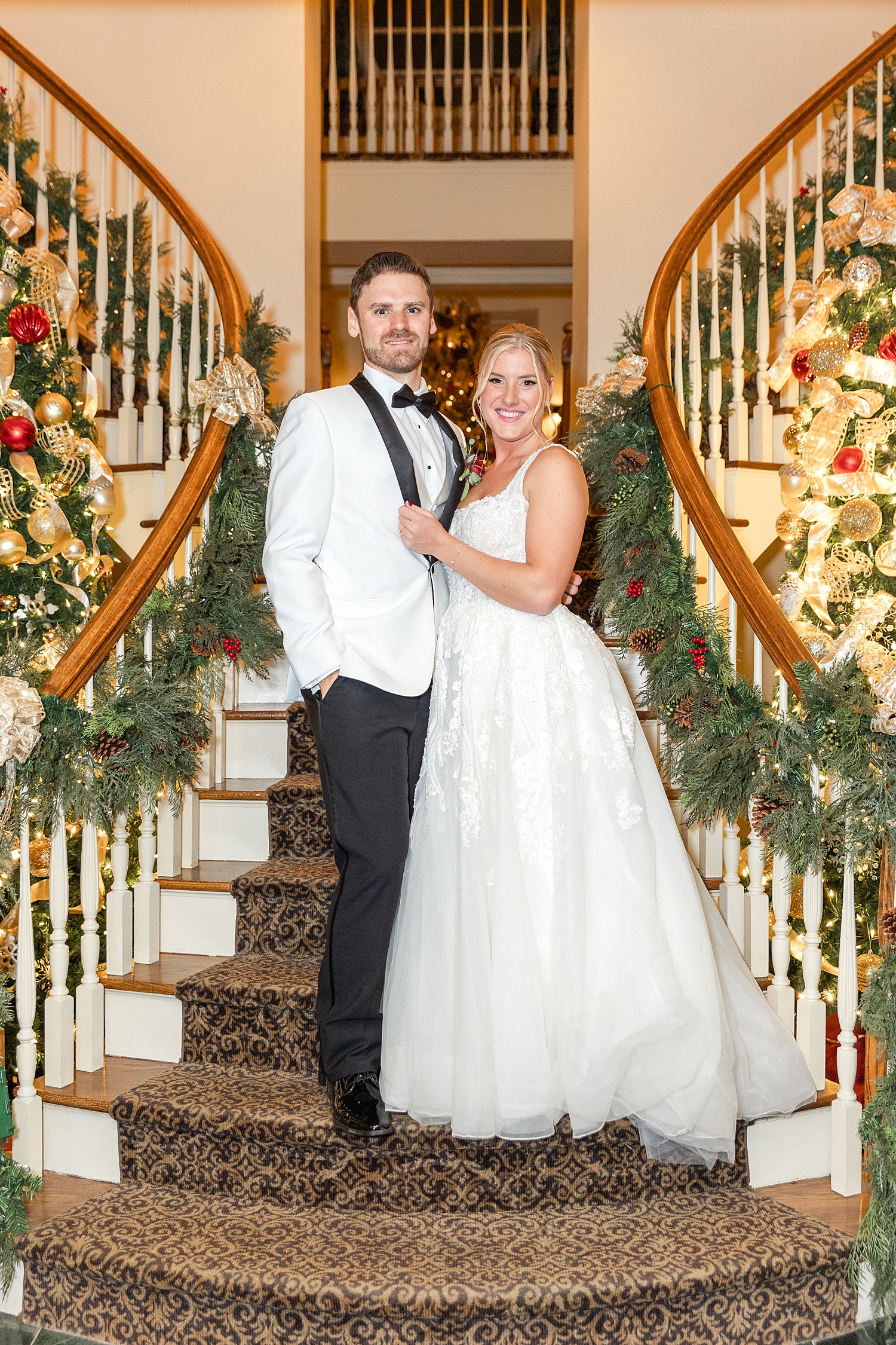 newlyweds on staircase decorated for Christmas