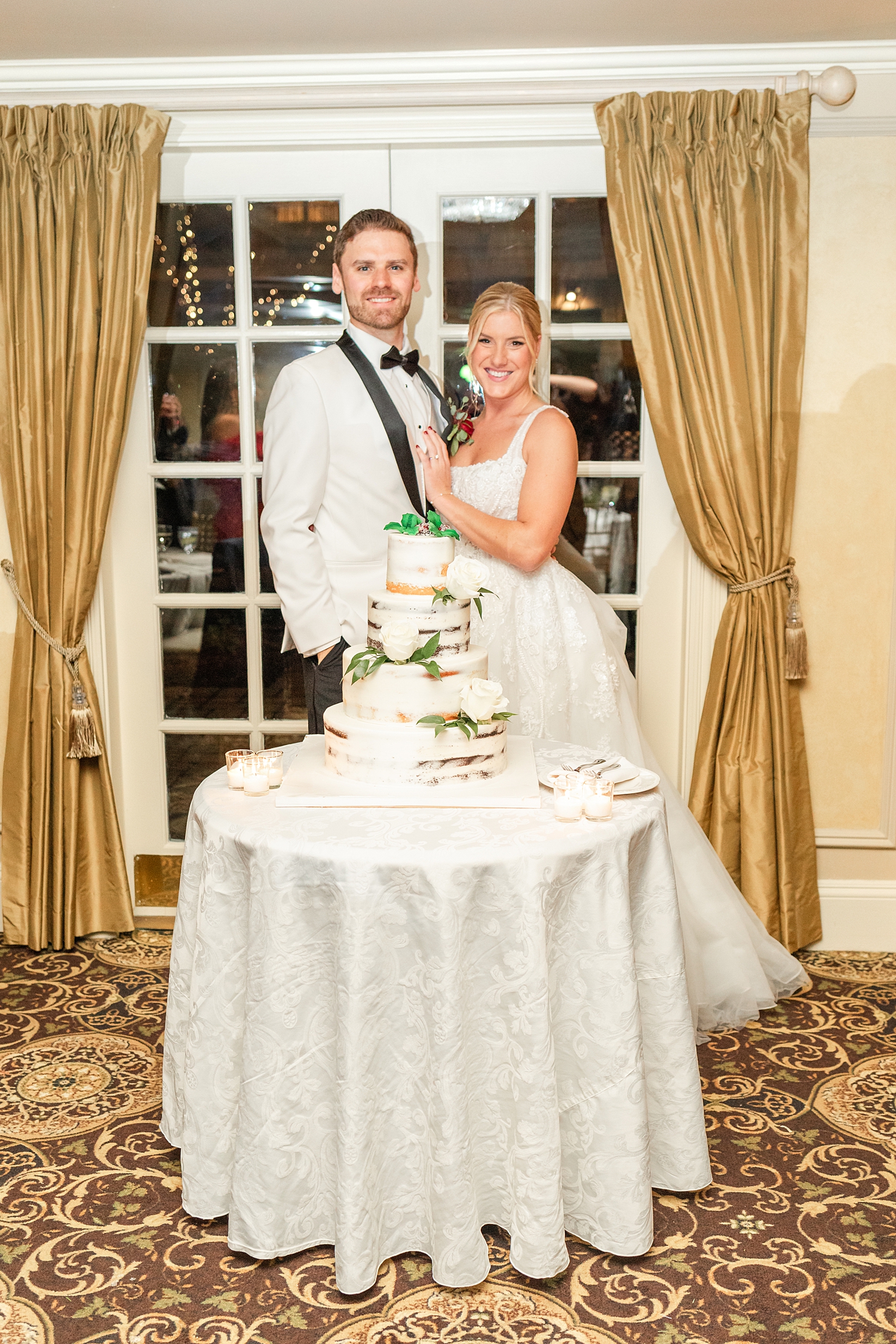 bride and groom in front wedding cake