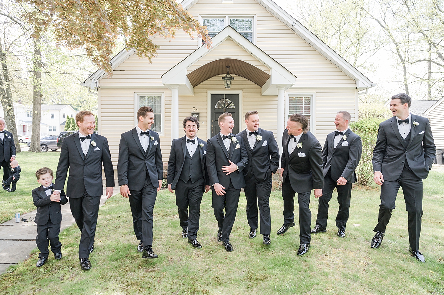 groom and groomsmen walk together outside