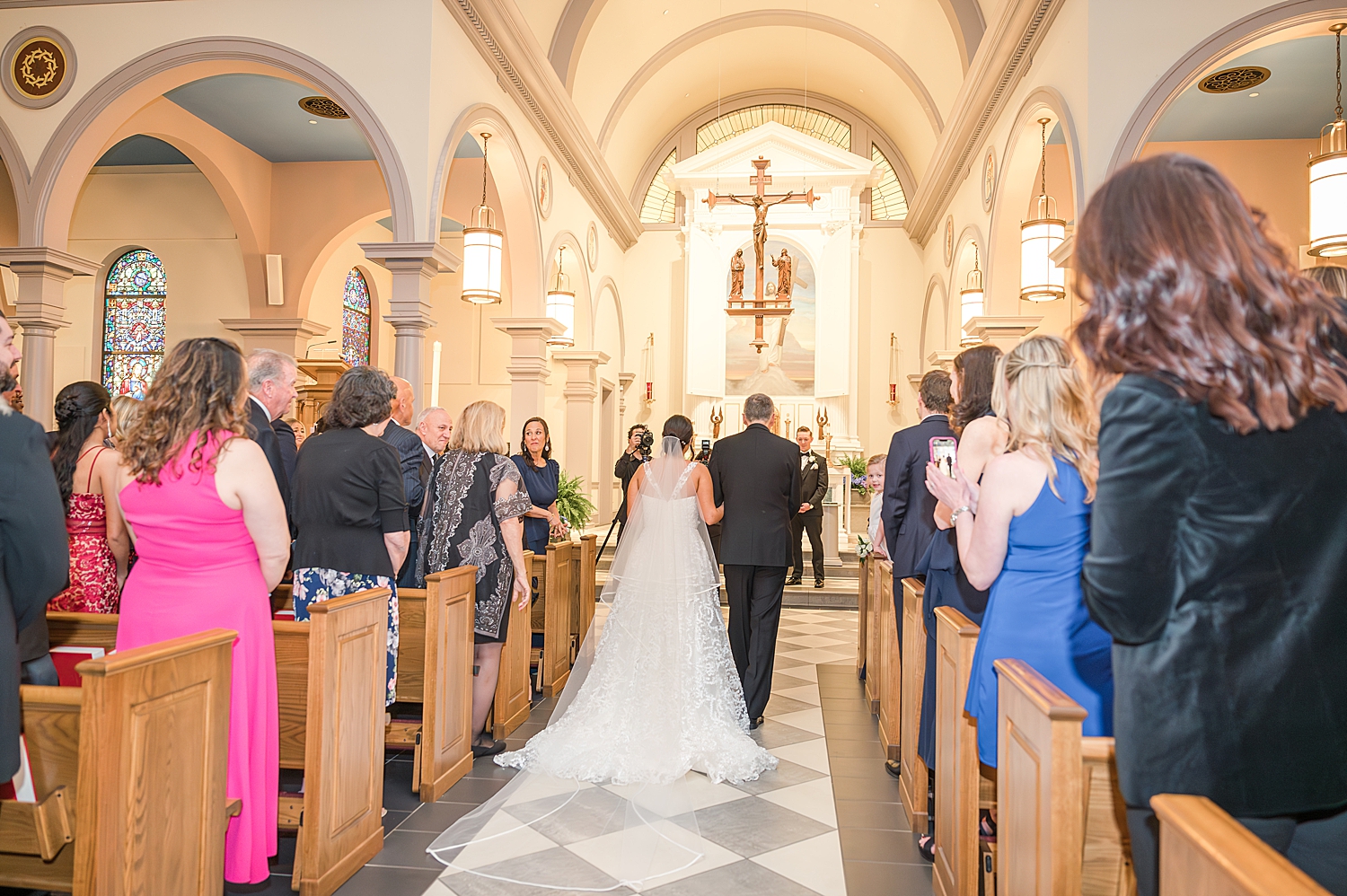 the back of bride's wedding dress as she walks down the aisle