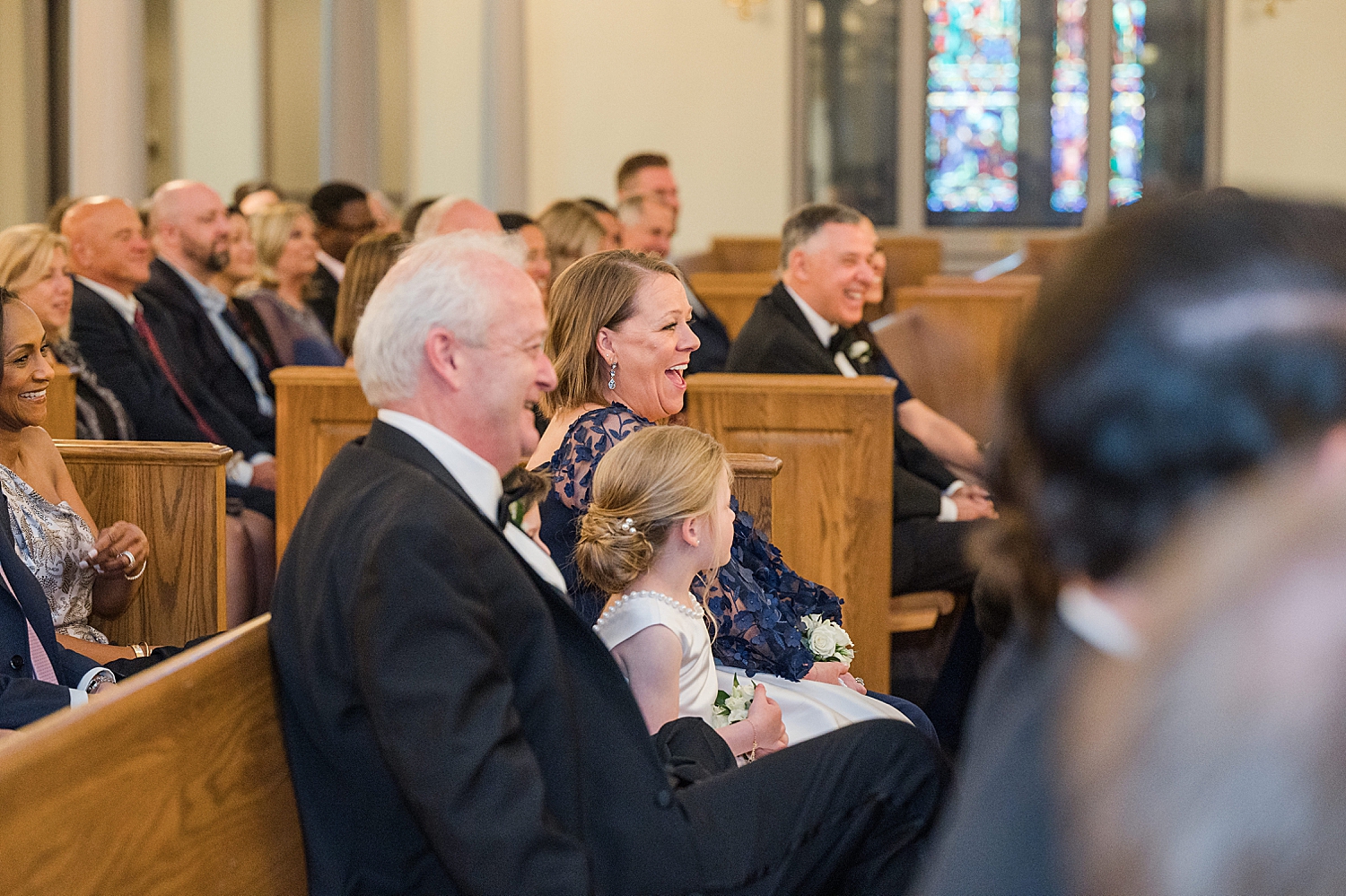 Wedding guests sit in pews during church wedding ceremony 