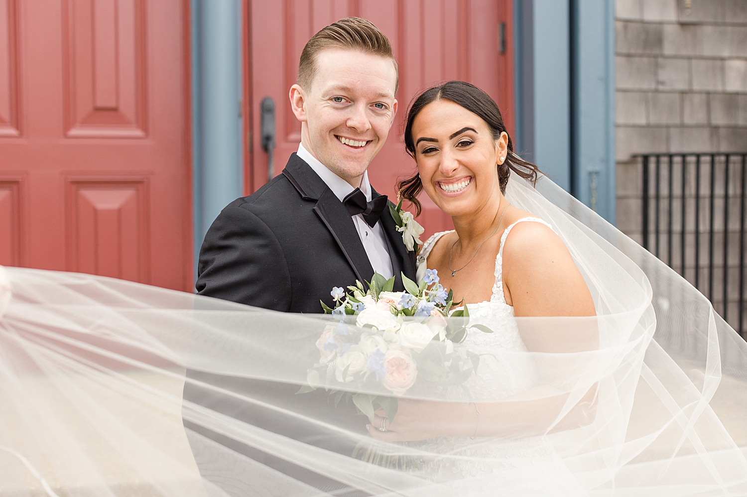 bride's veil flutters around newlyweds from Romantic Spring Wedding in New Jersey