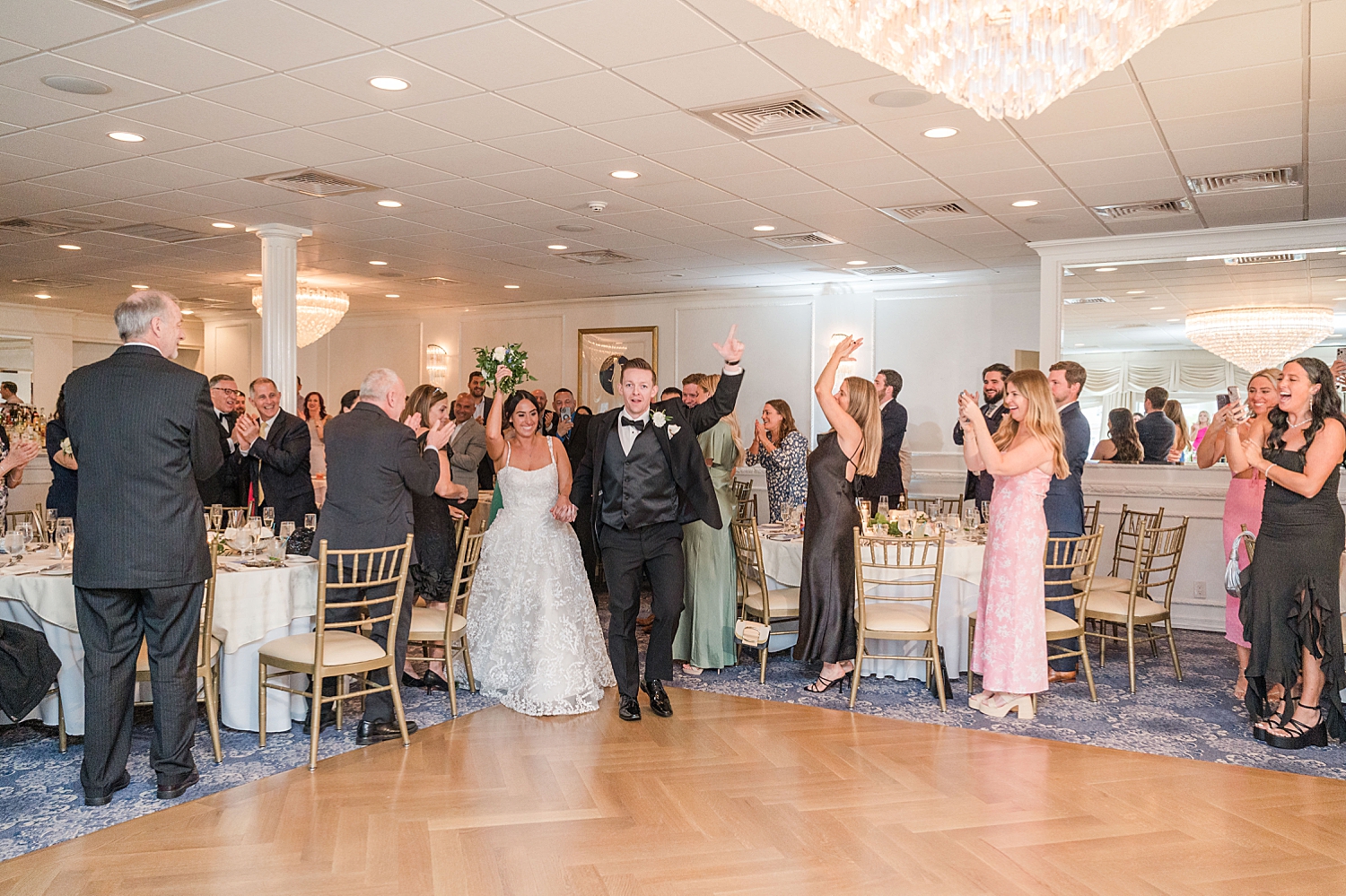 newlyweds enter wedding reception at Breakers Hotel on the Ocean