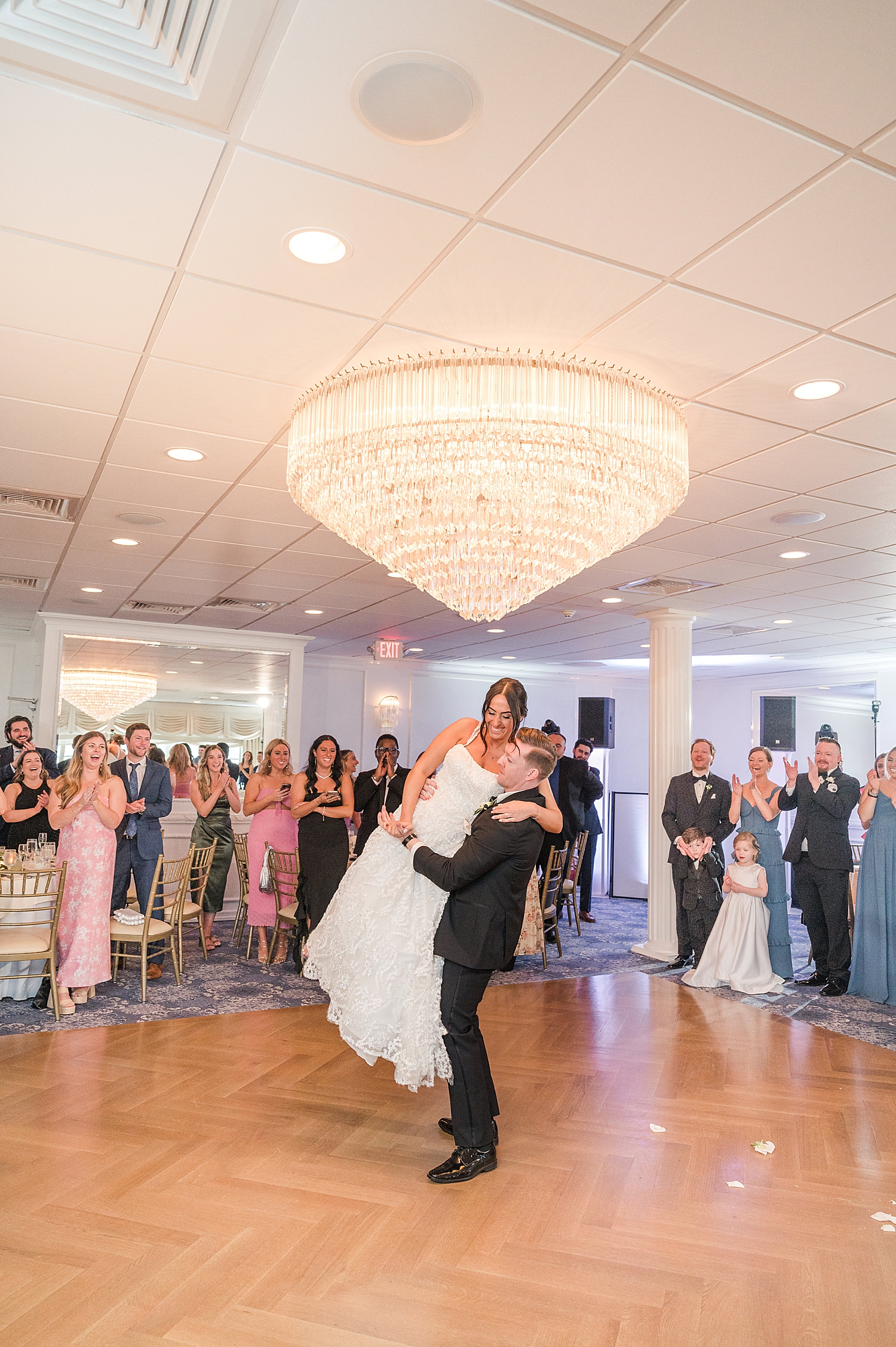 groom lifts bride up on the dance floor