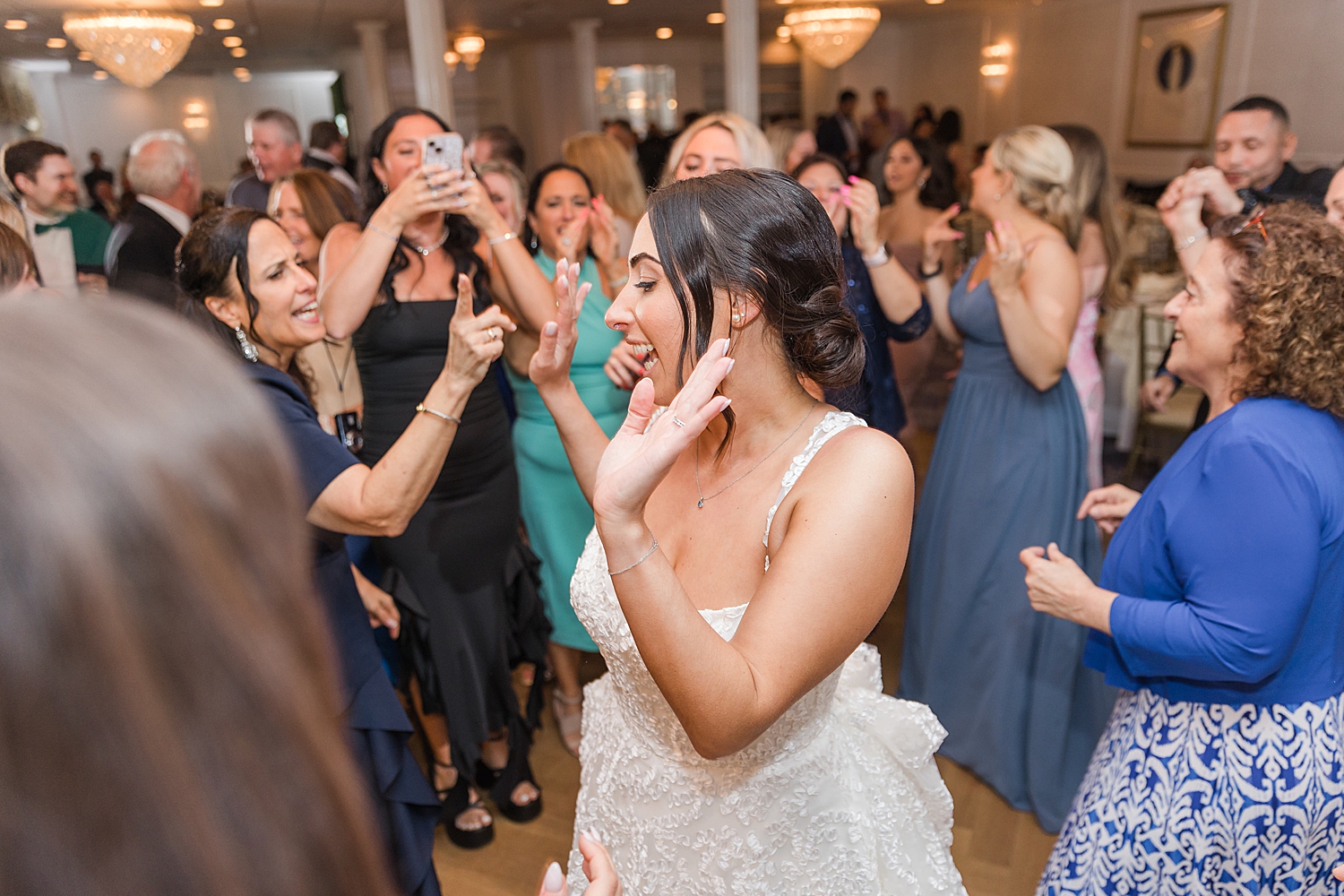 bride on the dance floor with friends and family 